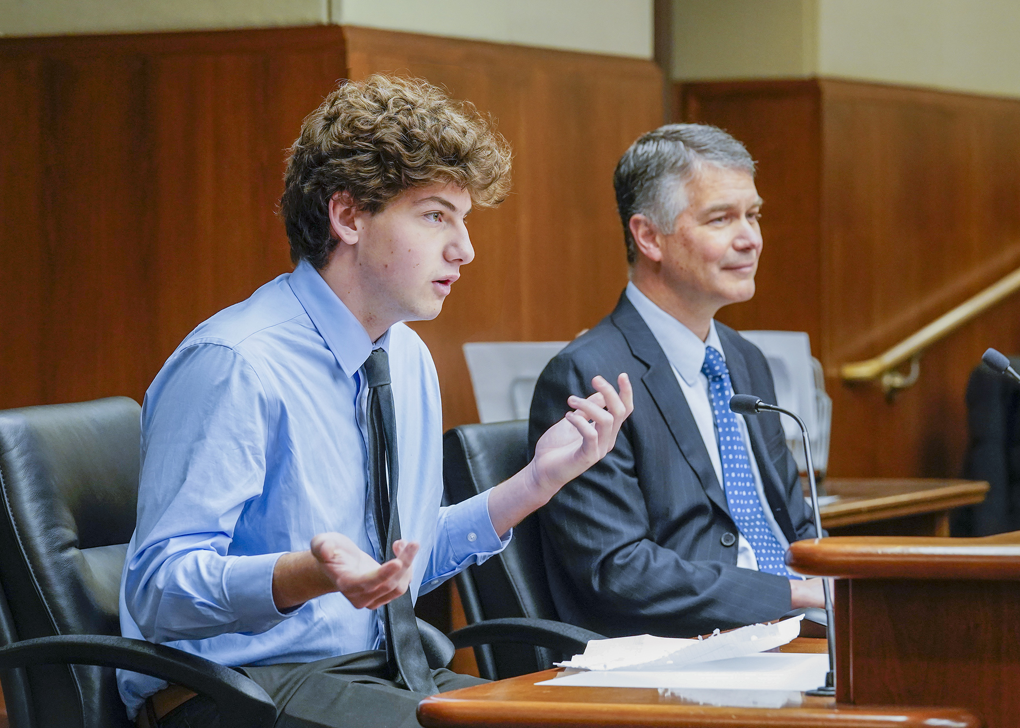Isaac Israel, a 17-year-old senior at St. Louis Park High School, testifies before the House Elections Finance and Policy Committee Jan. 11 in support of HF110, sponsored by Rep. Larry Kraft, right. (Photo by Andrew VonBank)