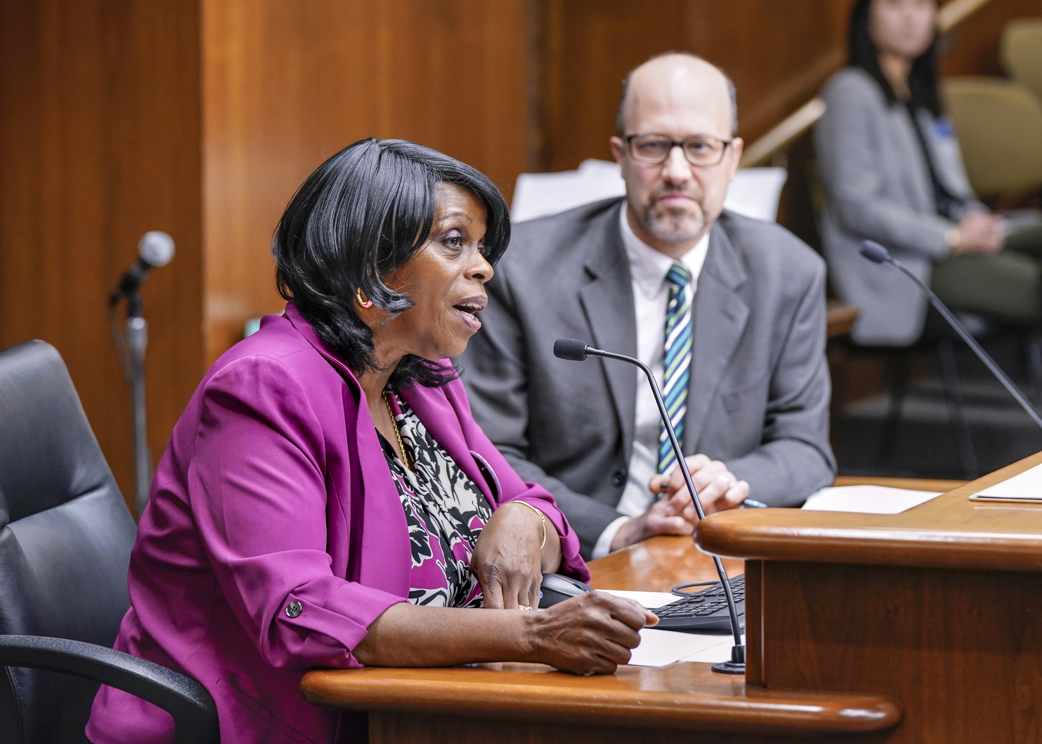 With Rep. Dave Pinto looking on, teacher and day care building owner Debra Messenger testifies Jan. 12 before the House Children and Families Finance and Policy Committee in support of HF150. (Photo by Catherine Davis)