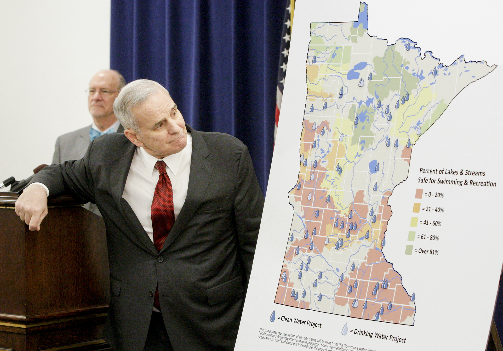 Gov. Mark Dayton looks at a map that shows a portion of his plan to update the state’s aging water infrastructure and protect water quality during a Jan. 14 news conference. Photo by Paul Battaglia