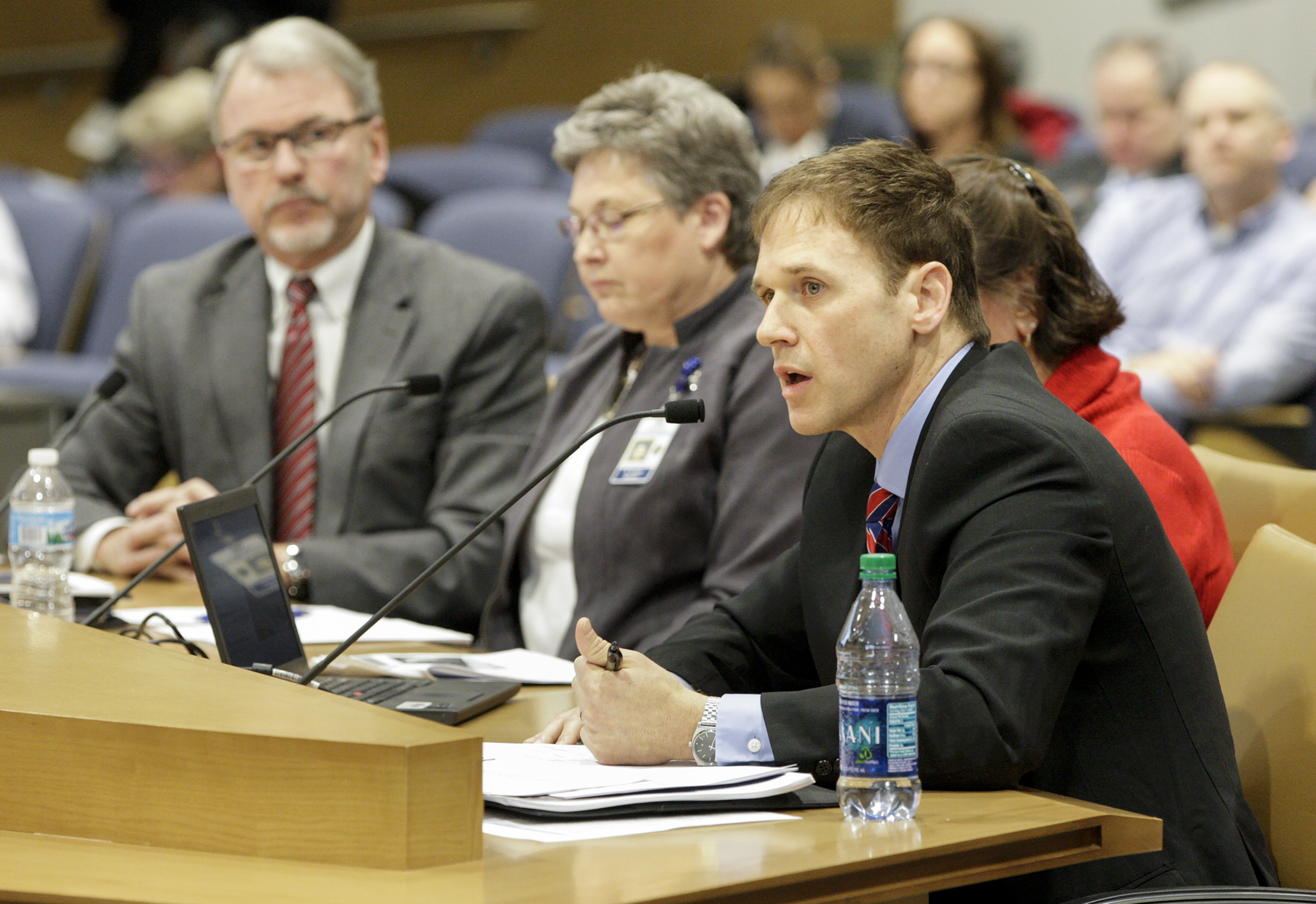 Dr. Grant Duwe, director of research for the Department of Corrections, gives members of the Prison Population Task Force a presentation on “Best Practices and Returns on Investment in the Corrections System.” Corrections Commissioner Tom Roy, from left, Warden Becky Dooley and Nanette Larson, the department’s health services director, also provided testimony. Photo by Paul Battaglia