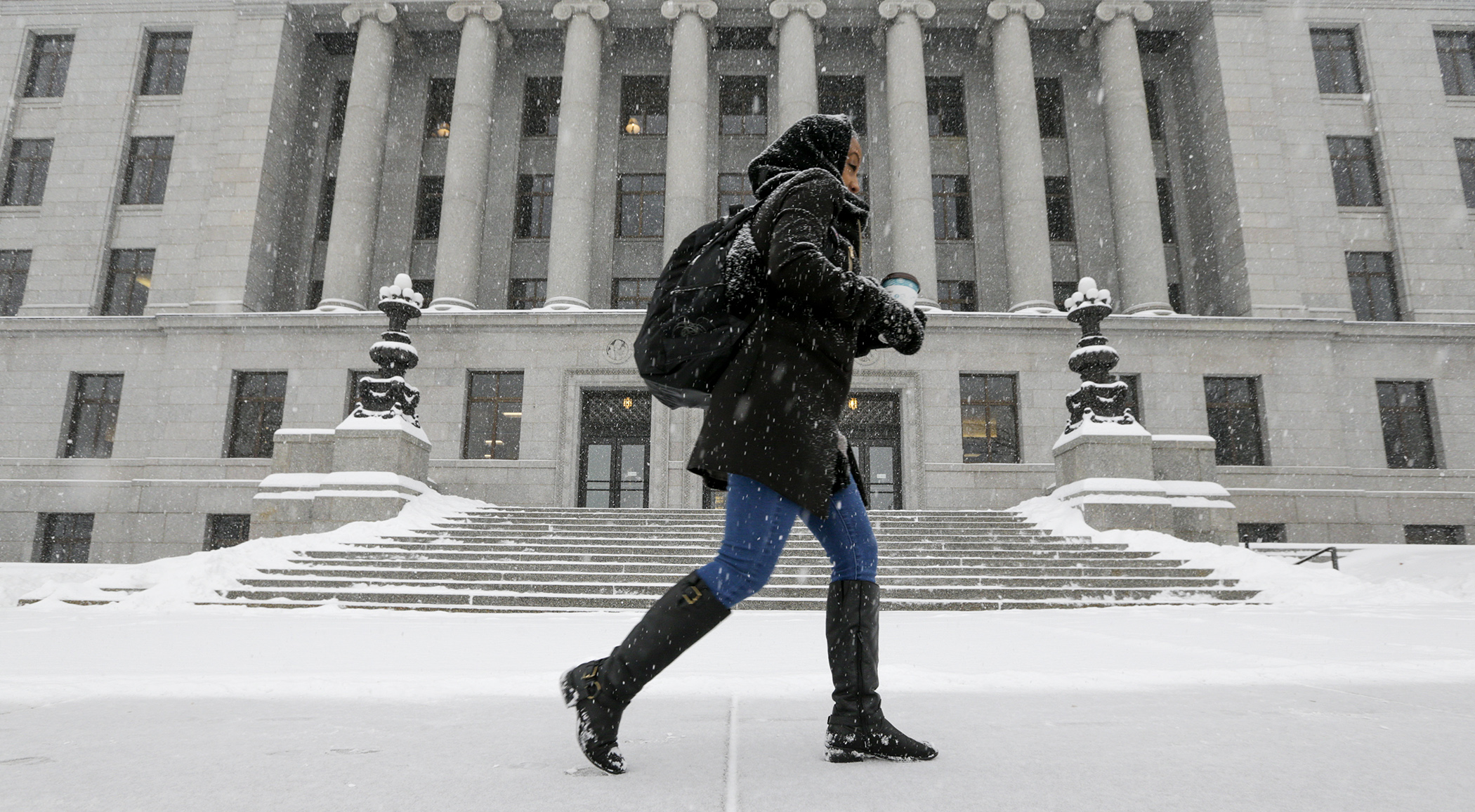 Coffee in hand, a visitor walked past the State Office Building Feb. 7 as another round of snow blanketed the Capitol Mall. | Photo by Paul Battaglia