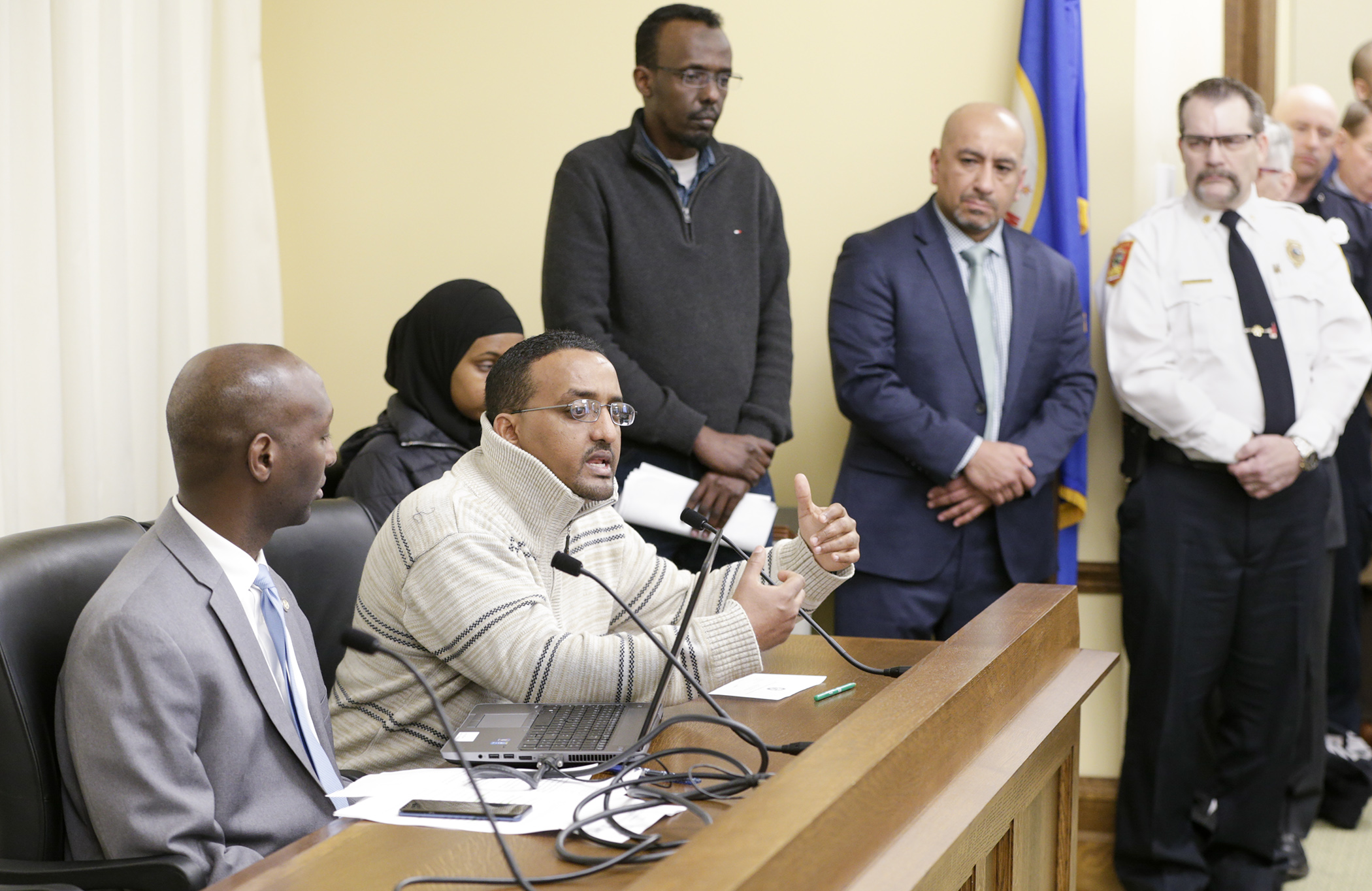 Hassanen Mohamed provides emotional testimony on HF3003 that would require automatic sprinkler systems be installed in certain existing high-rise  buildings. Rep. Mohamud Noor, left, sponsors the bill. Photo by Paul Battaglia 