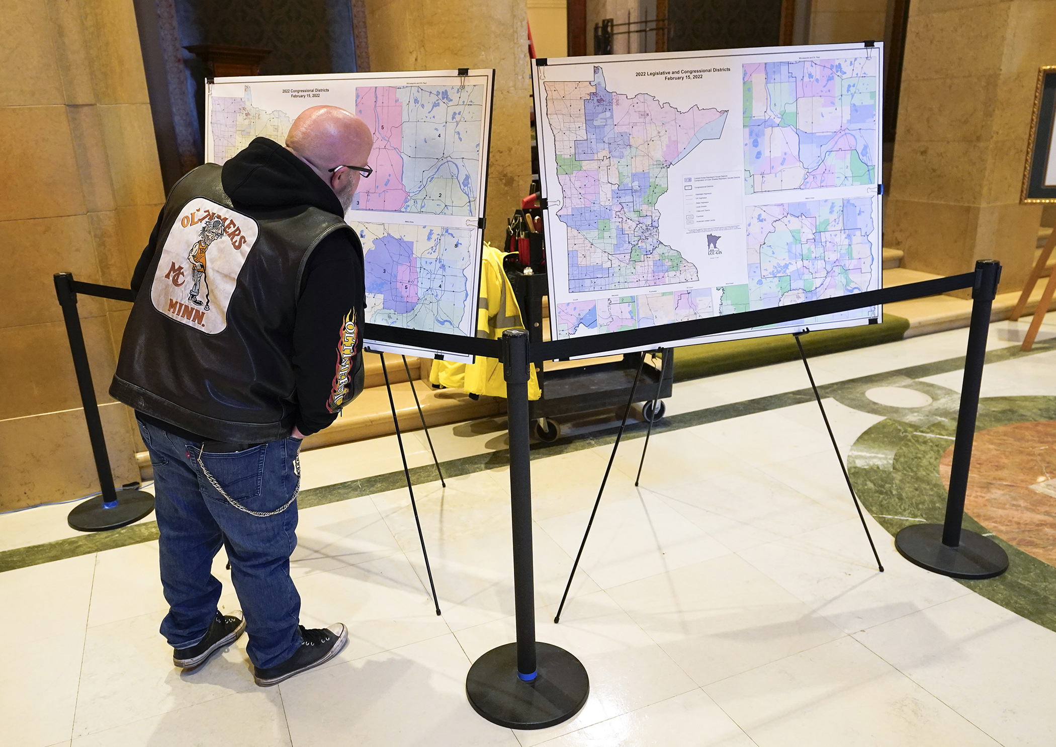 Joe Krauss of Coon Rapids looks over a set of the new congressional and legislative district maps on display outside the House Chamber Feb. 16. (Photo by Paul Battaglia)