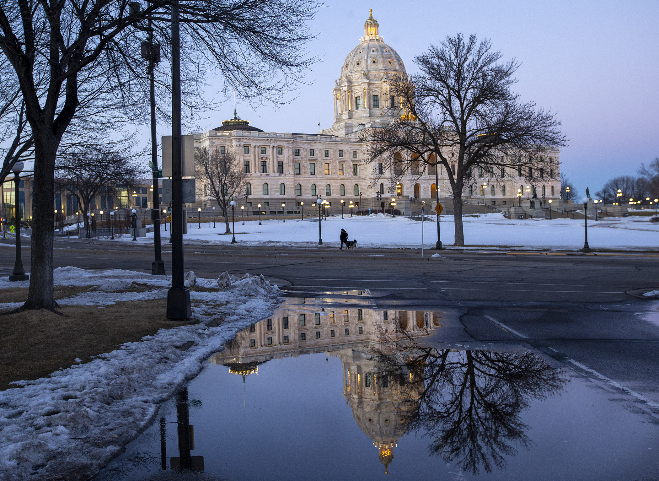 The Capitol is reflected in a puddle of melted snow at dusk Feb. 25. Photo by Paul Battaglia
