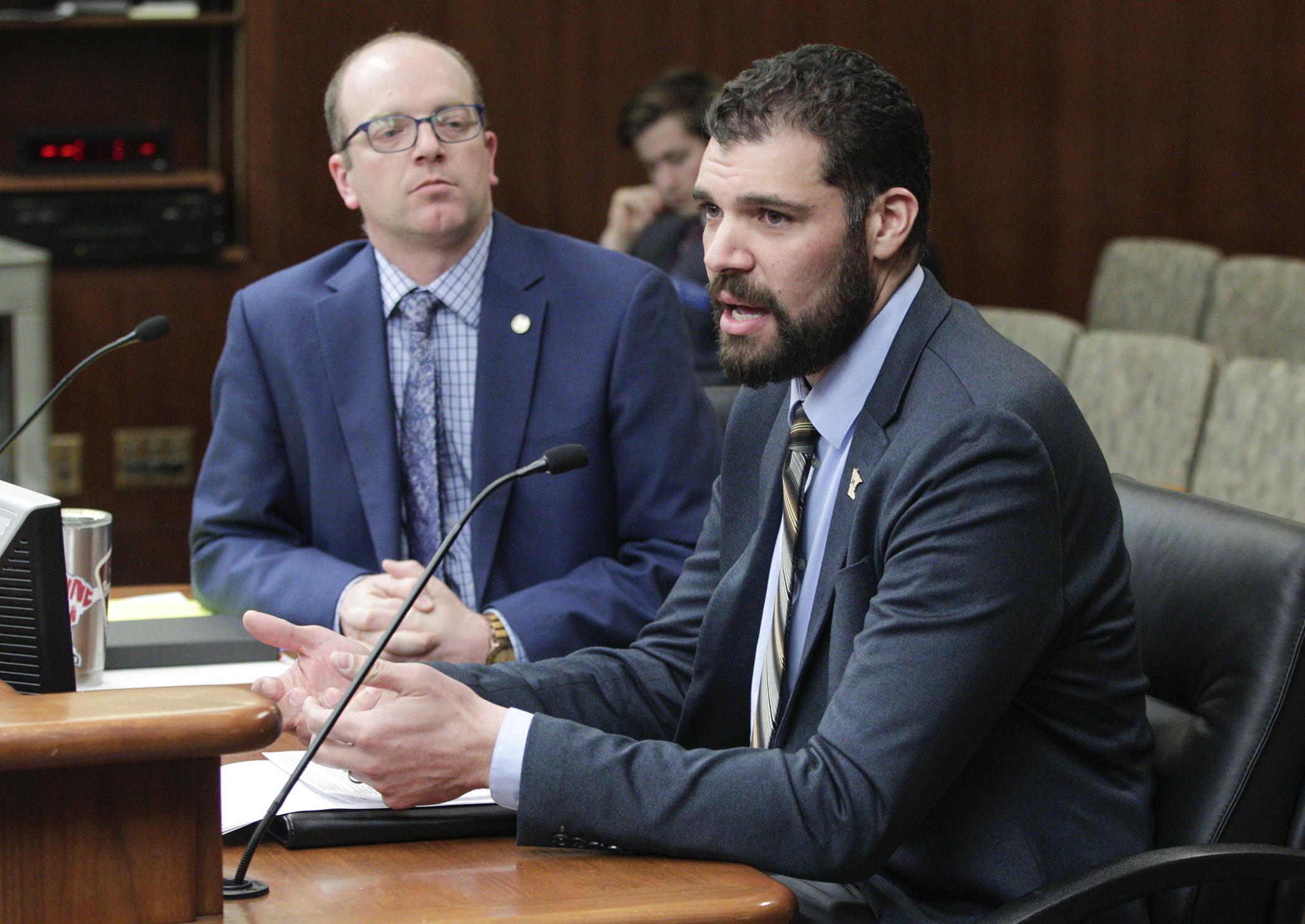 Jeremiah Carter, University of Minnesota athletic compliance director, testifies on HF3908, sponsored by Rep. Brad Tabke, left, in the House Higher Education Finance and Policy Division March 4. The bill would allow student athletes to be compensated for us