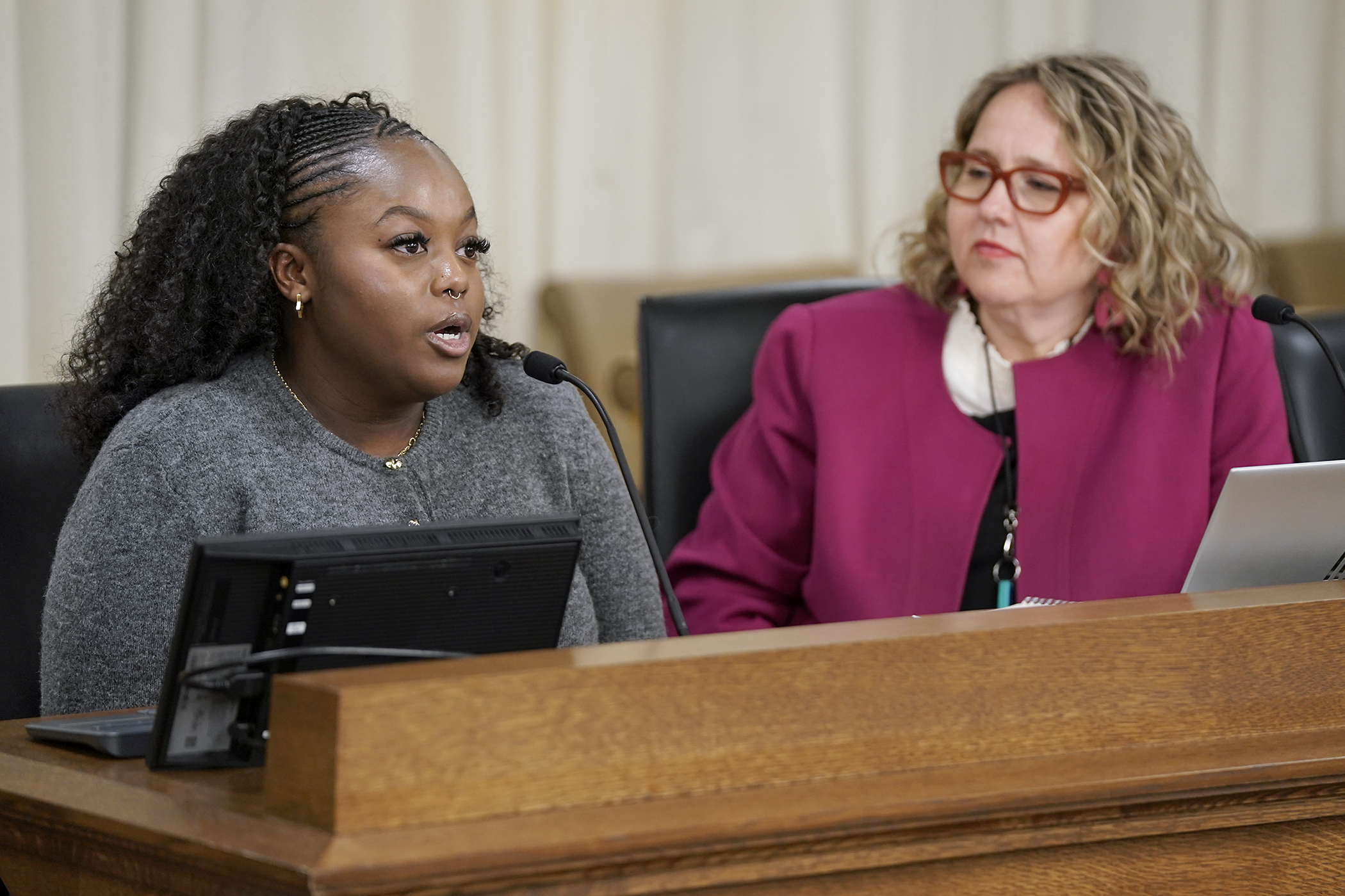 Hanna Ford testifies March 11 before the House Workforce, Labor, and Economic Development Finance and Policy Committee in support of a bill sponsored by Rep. Emma Greenman, right, to prohibit some stay-or-pay provisions. (Photo by Michele Jokinen)
