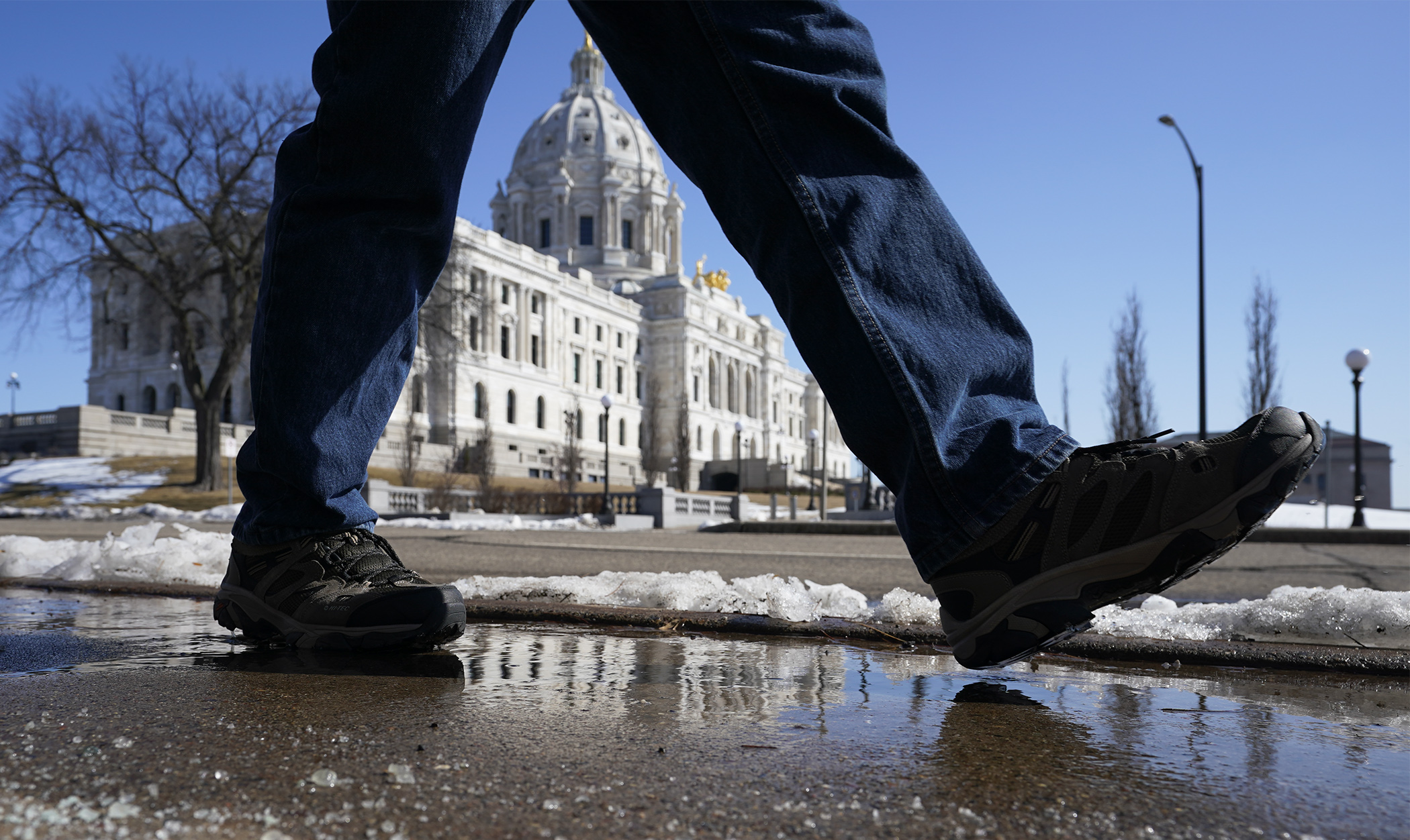 A Capitol visitor takes advantage of spring-like temperatures on a midday walk near the State Office Building March 15. (Photo by Paul Battaglia)