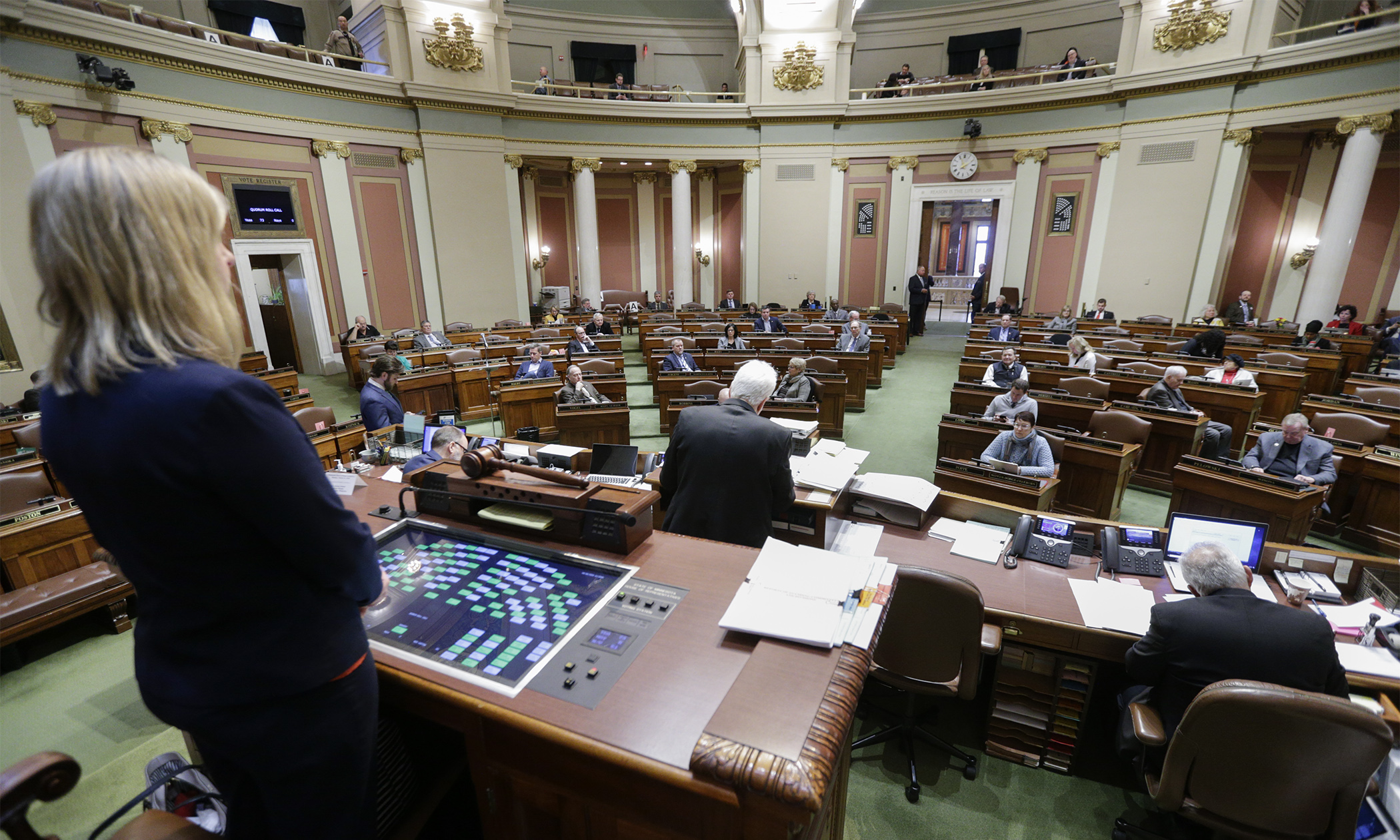 House Speaker Melissa Hortman stands at her desk as Chief Clerk Patrick Murphy does a quorum call by voice at the start of session March 16. Photo by Paul Battaglia