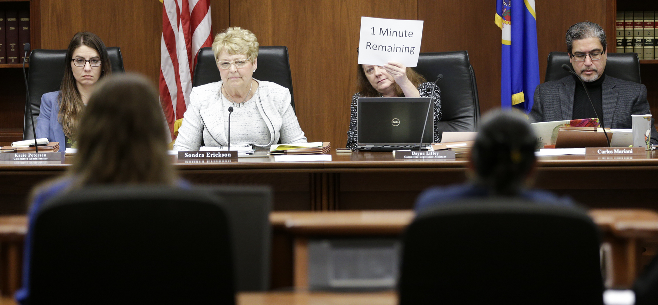 House Education Innovation Policy Committee legislative assistant Dayna Liffey indicates the time remaining for a testifier, as the committee takes testimony on the delete-all amendment to HF3315, the omnibus E-12 education policy bill. Photo by Paul Battaglia