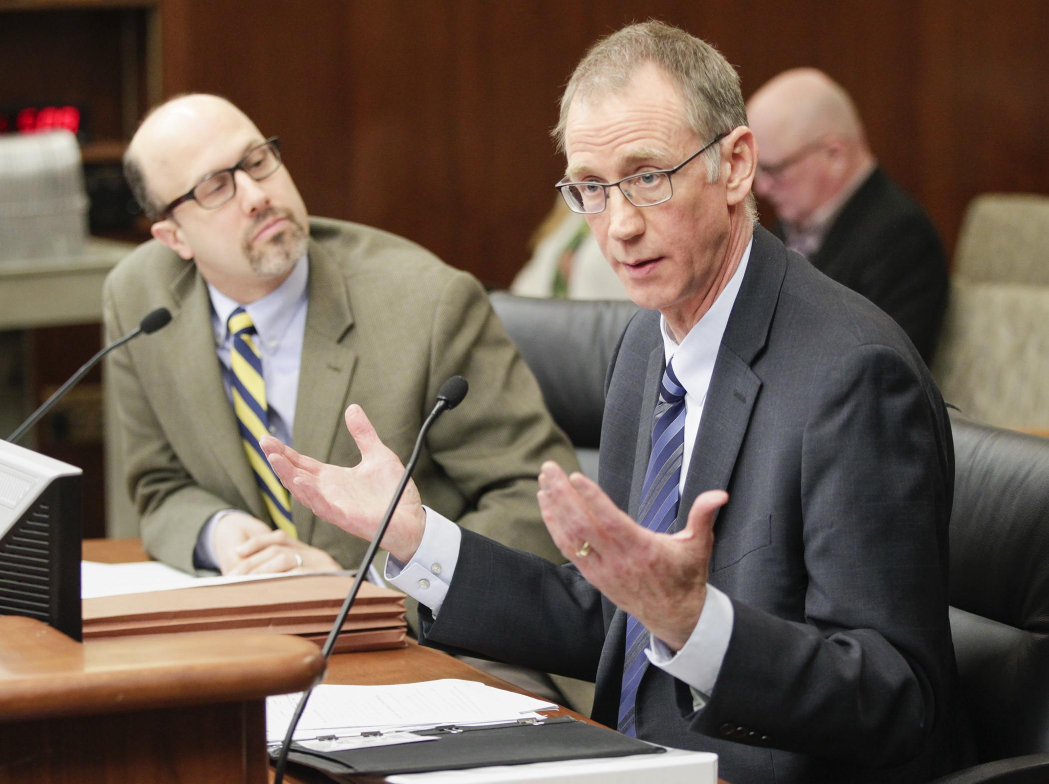 Deputy Human Services Commissioner Chuck Johnson testifies before the House Judiciary Finance and Civil Law Division on HF2319, sponsored by Rep. Dave Pinto, left. Photo by Paul Battaglia