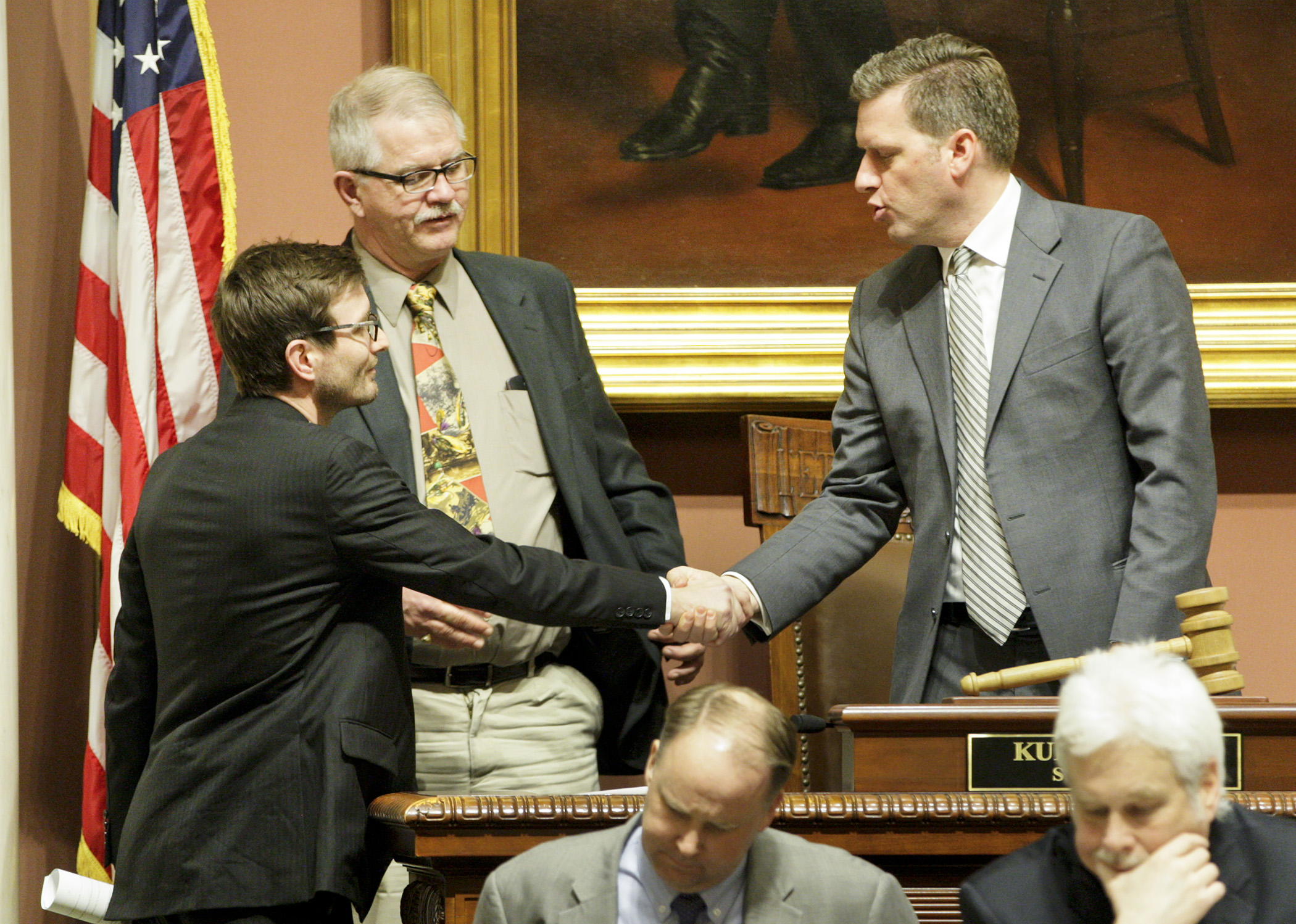 House Speaker Kurt Daudt, right, shakes hands with Rep. Jason Metsa after session had adjourned and the House passed a 26-week unemployment extension bill for workers on the Iron Range. Rep. Rob Ecklund, center, looks on. Photo by Paul Battaglia