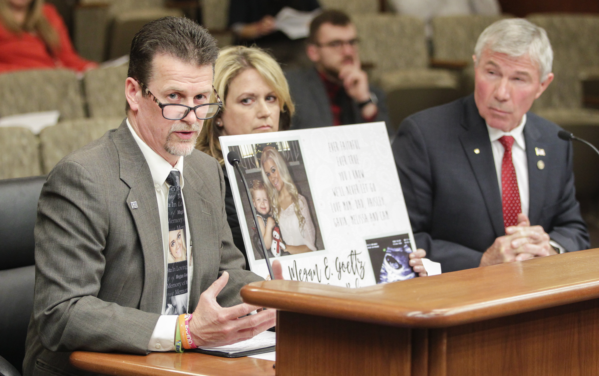 Tom Goeltz testifies as his wife Wendy holds a photo of their daughter, Megan in the House transportation division. They spoke in support of HF104, a bill that would increase penalties for electronic messaging while driving. Photo by Paul Battaglia