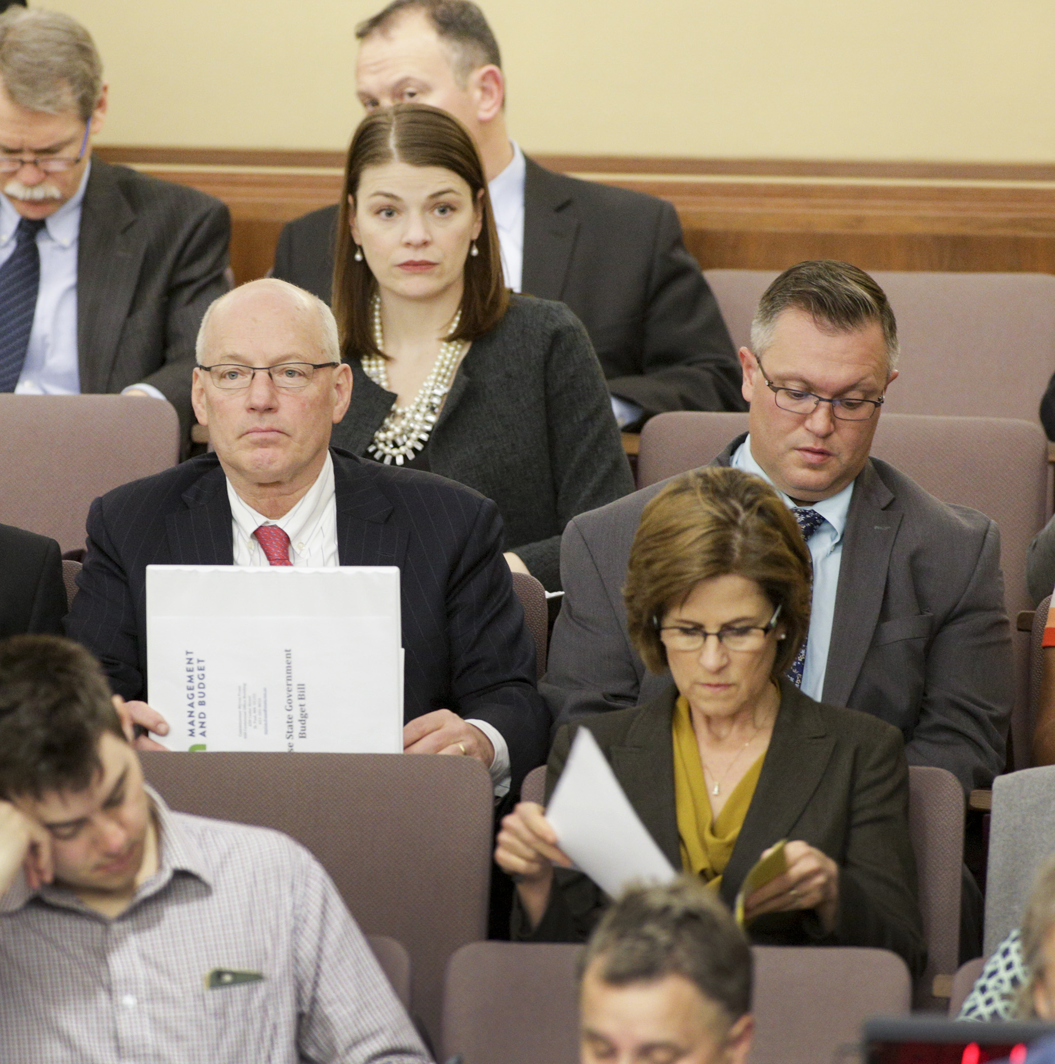 Several interested parties, including Revenue Commissioner Cynthia Bauerly, back left, Minnesota Management and Budget Commissioner Myron Frans, center, and State Auditor Rebecca Otto, look on March 27 as House State Government Finance Committee staff do a run-through of the committee’s omnibus bill. Photo by Paul Battaglia