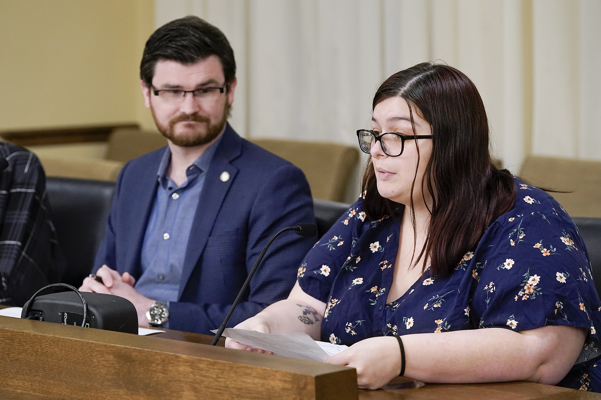 With Rep. Nolan West, the bill sponsor, looking on, Janice DeGonda testifies in support of HF1915 before the House Judiciary Finance and Civil Law Committee March 27. The proposal would require licensed child care centers to use video security cameras to monitor infants and toddlers. (Photo by Michele Jokinen)