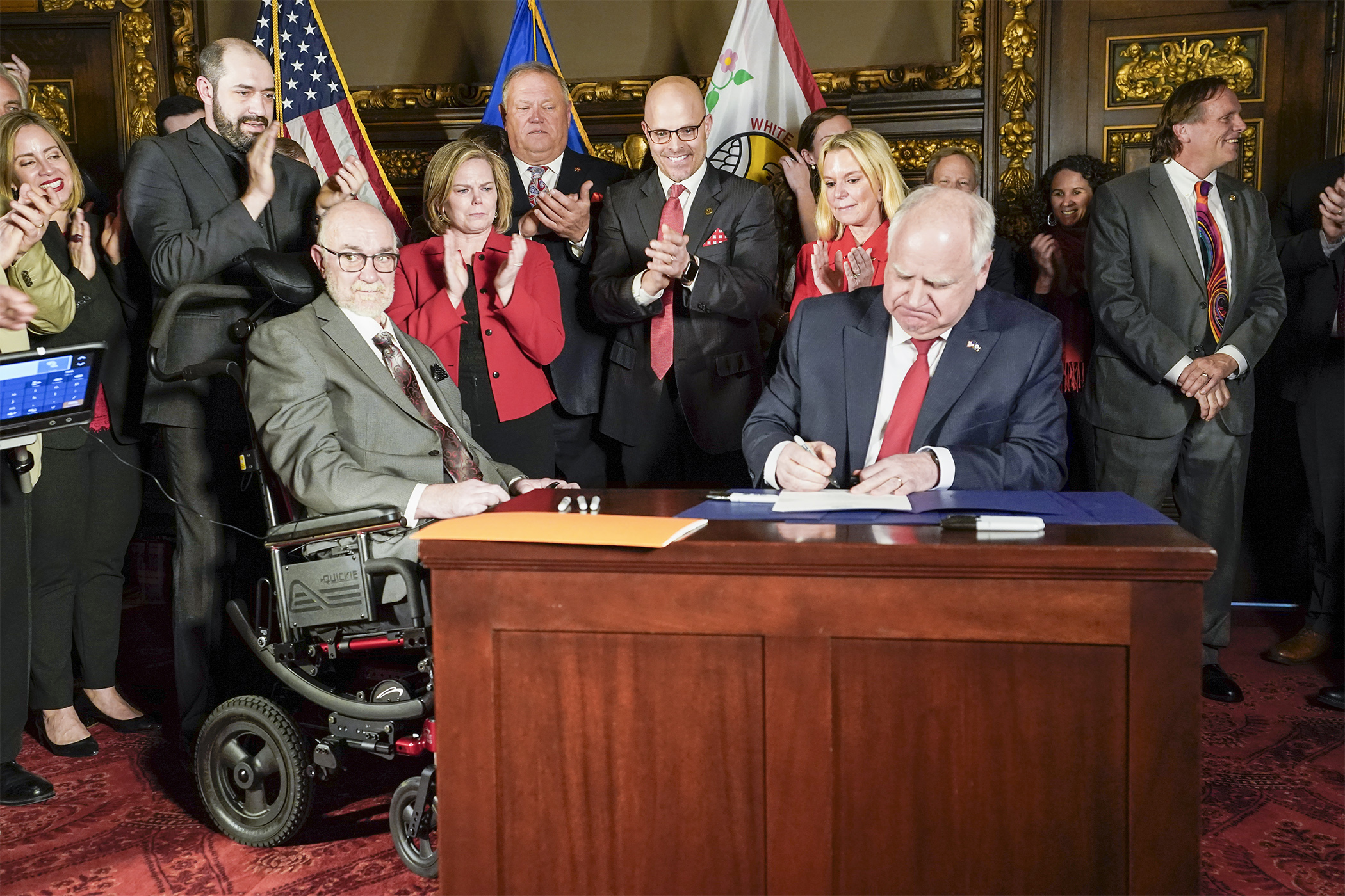 Gov. Tim Walz signs into law a bill to provide $25 million for ALS research and caregiver support March 30. Also pictured are Sen. David Tomassoni, Rep. Anne Neu Brindley, Sen. Tom Bakk, Rep. Dave Lislegard and Sen. Karin Housley. (Photo by Paul Battaglia)