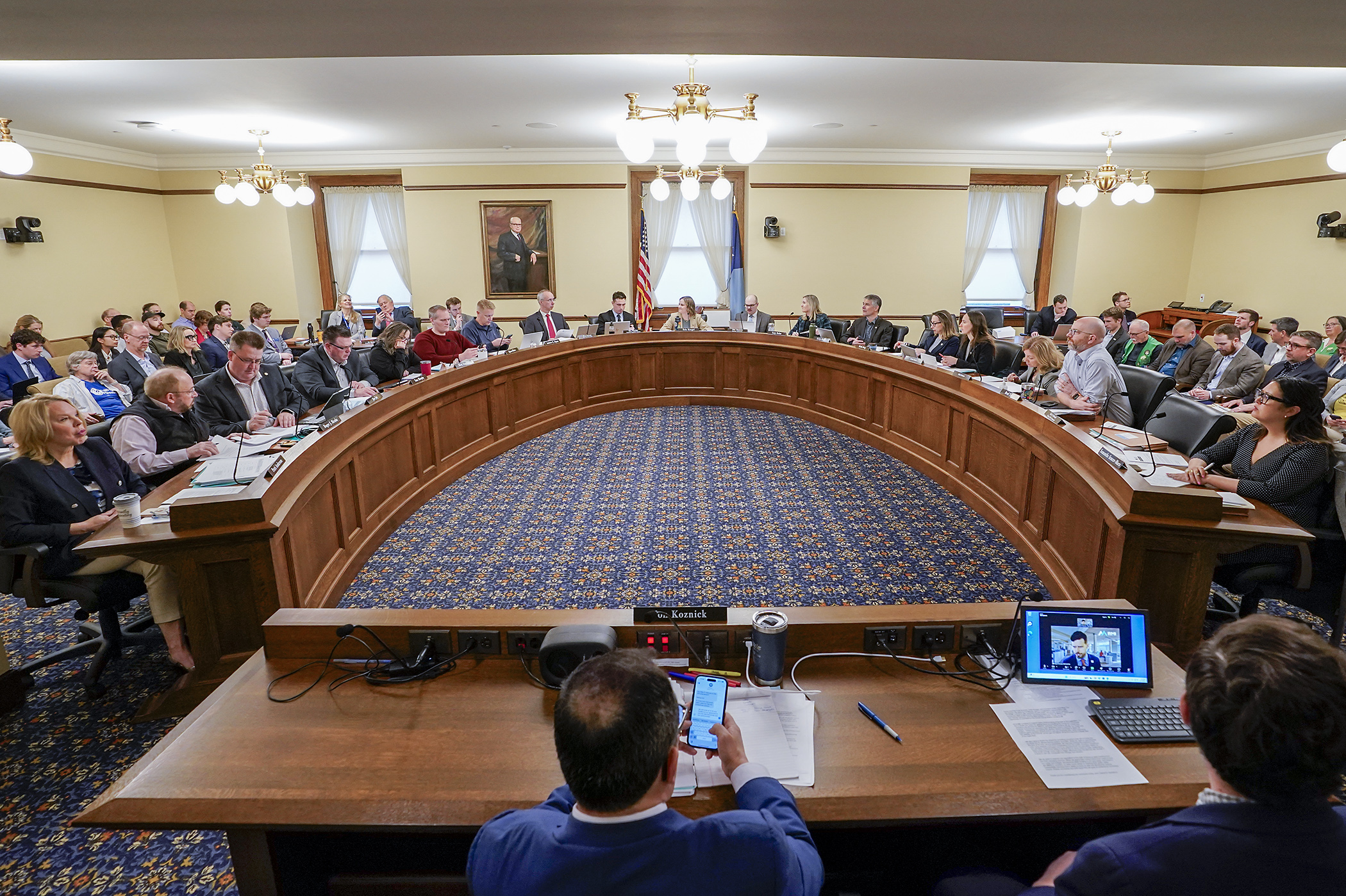 The House Transportation Finance and Policy Committee listens to an online testifier regarding HF2438. (Photo by Michele Jokinen)
