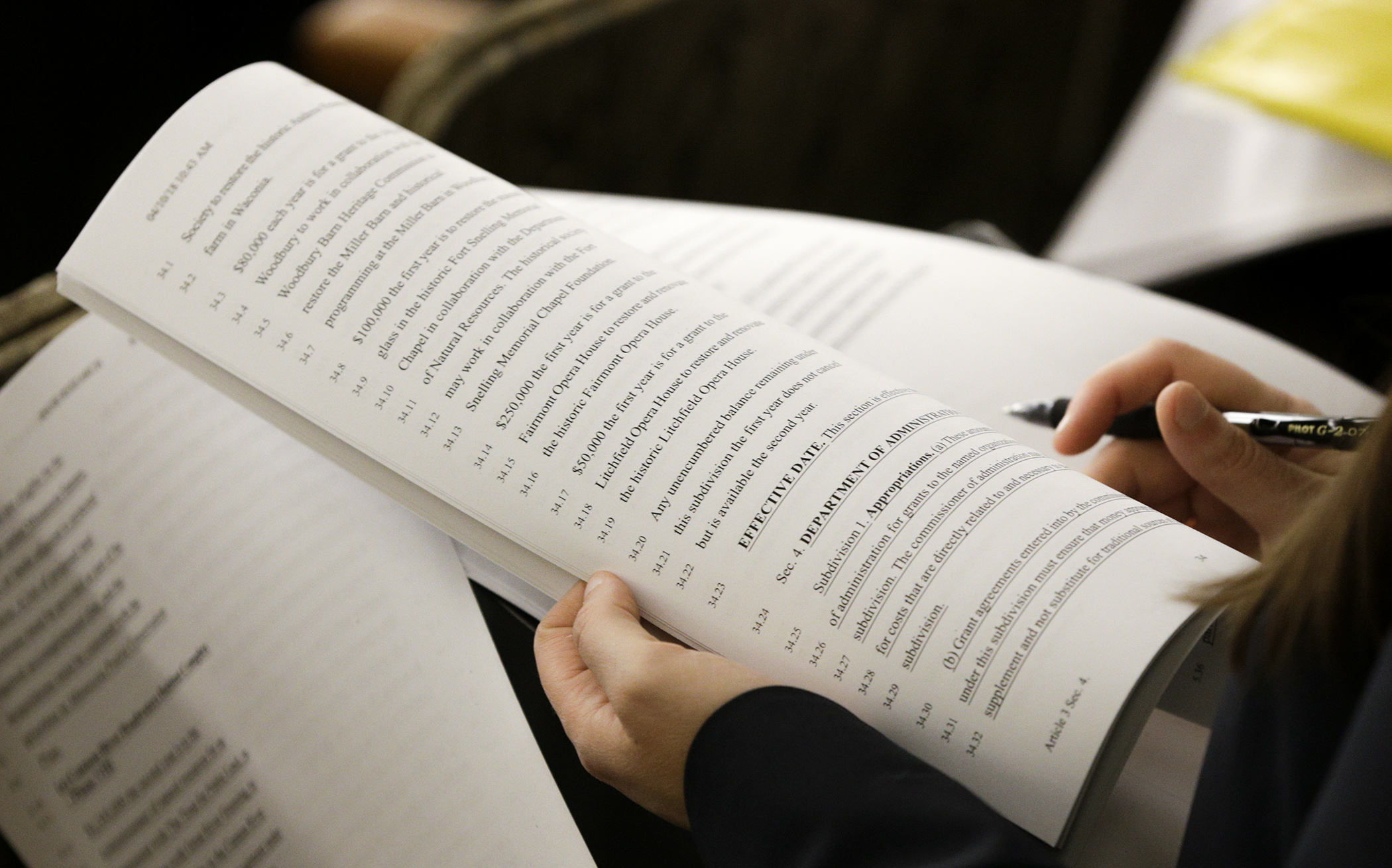 A member of the audience looks through HF4167, the omnibus Legacy finance bill during Monday’s hearing in the House Legacy Funding Finance Committee. Photo by Paul Battaglia