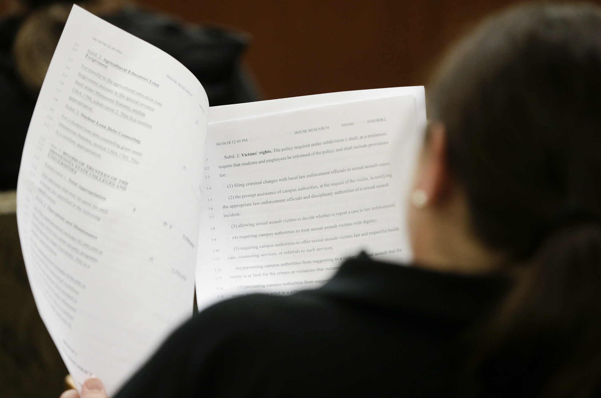 A member of the audience follows along April 17 as staff from the House Higher Education and Career Readiness Policy and Finance Committee begin a run-through HF3638, the omnibus higher education finance bill. Photo by Paul Battaglia