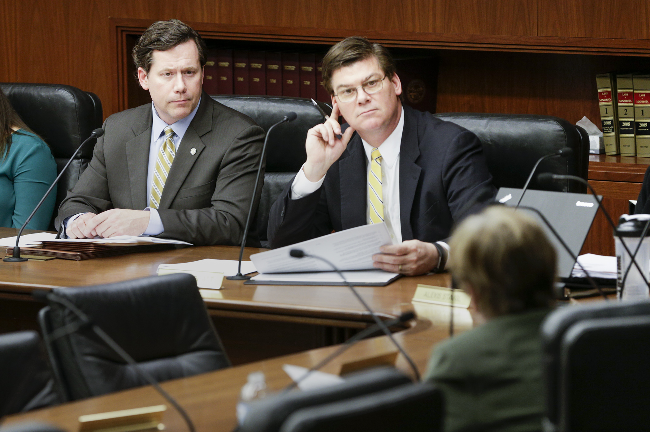 Rep. Dennis Smith, left, and Sen. Eric Pratt, co-chairs of the conference committee on HF3, the Real ID implementation bill, listen to a question from Sen. Ann Rest, right foreground, at their first meeting April 18. Photo by Paul Battaglia