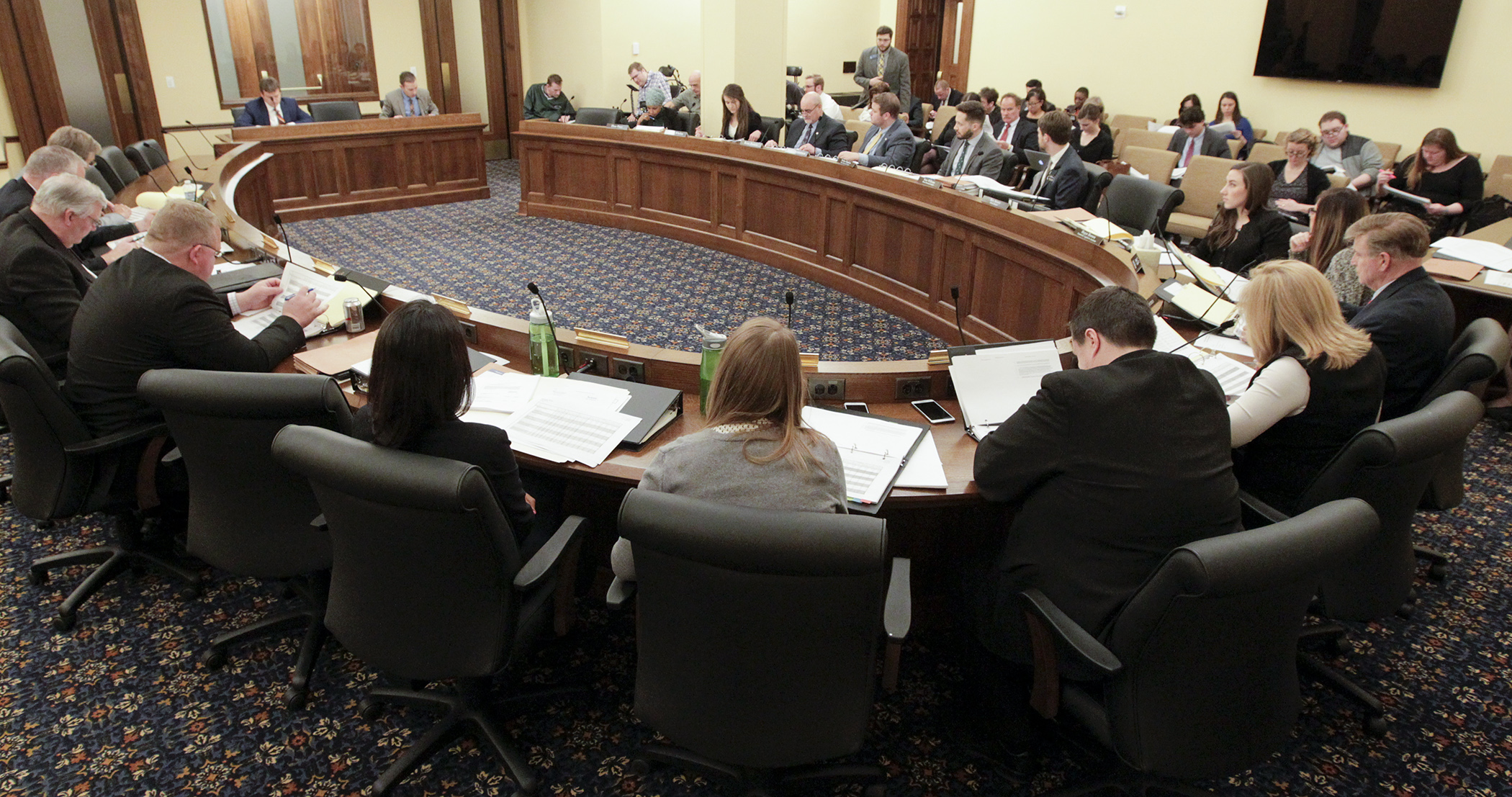 Members of the omnibus higher education policy and finance conference committee listen as staff does a walk-through of the House and Senate bills during the first meeting April 19. Photo by Paul Battaglia