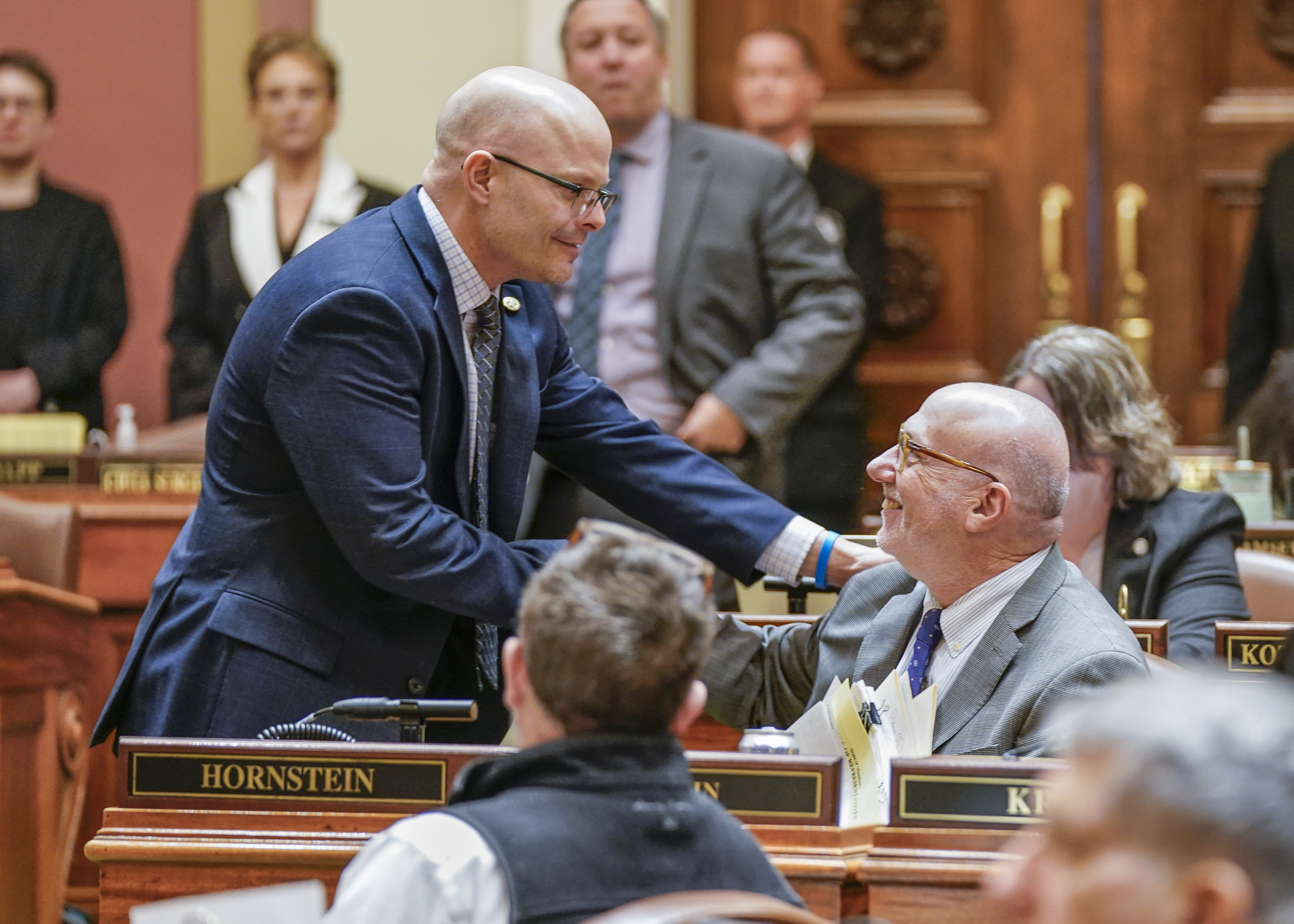 Rep. Dave Lislegard, left, congratulates Rep. Frank Hornstein on passage of the omnibus transportation finance bill April 19. (Photo by Catherine Davis)