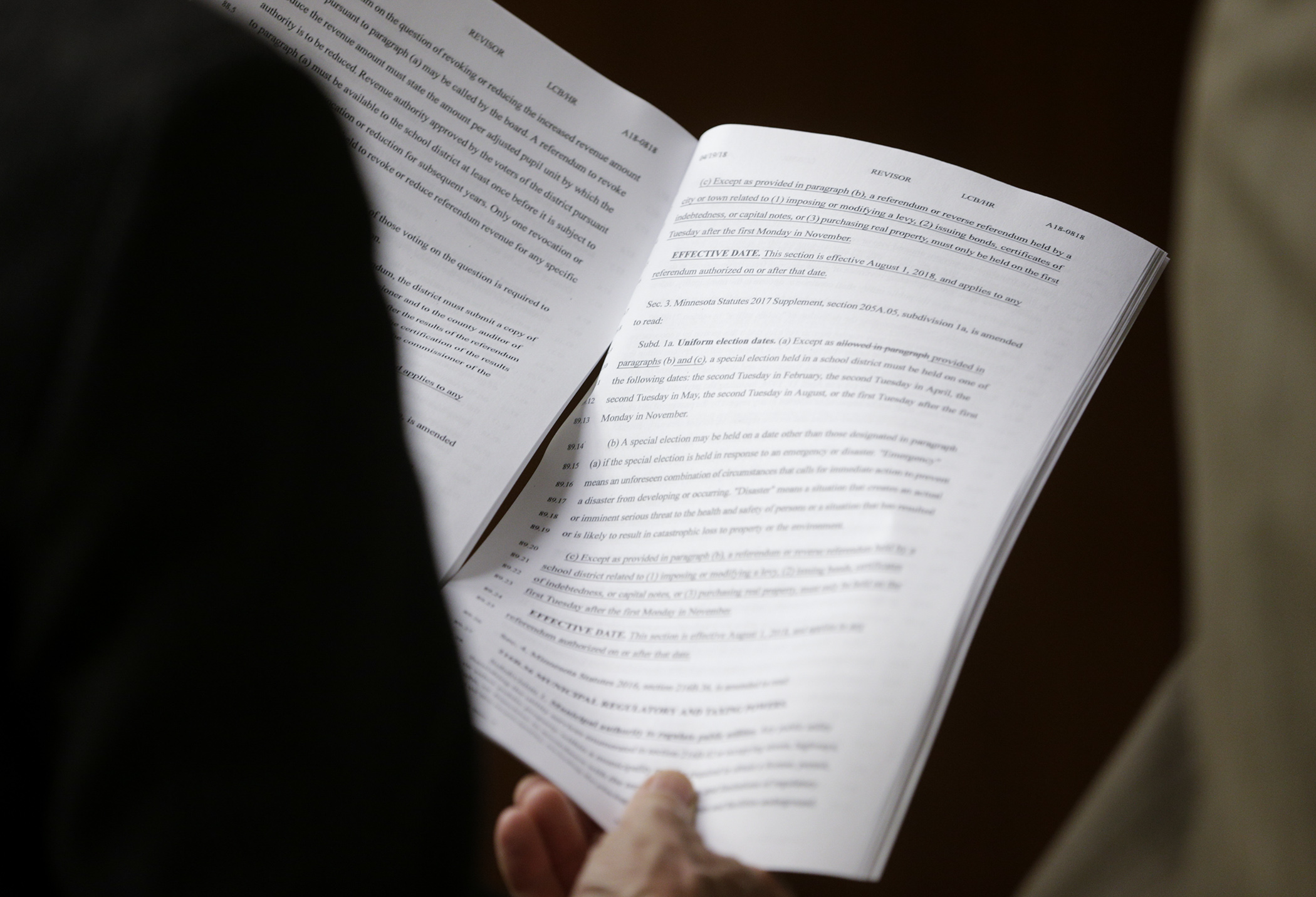 Members of the audience in the House Property Tax and Local Government Finance Division look through the division report April 20. Photo by Paul Battaglia