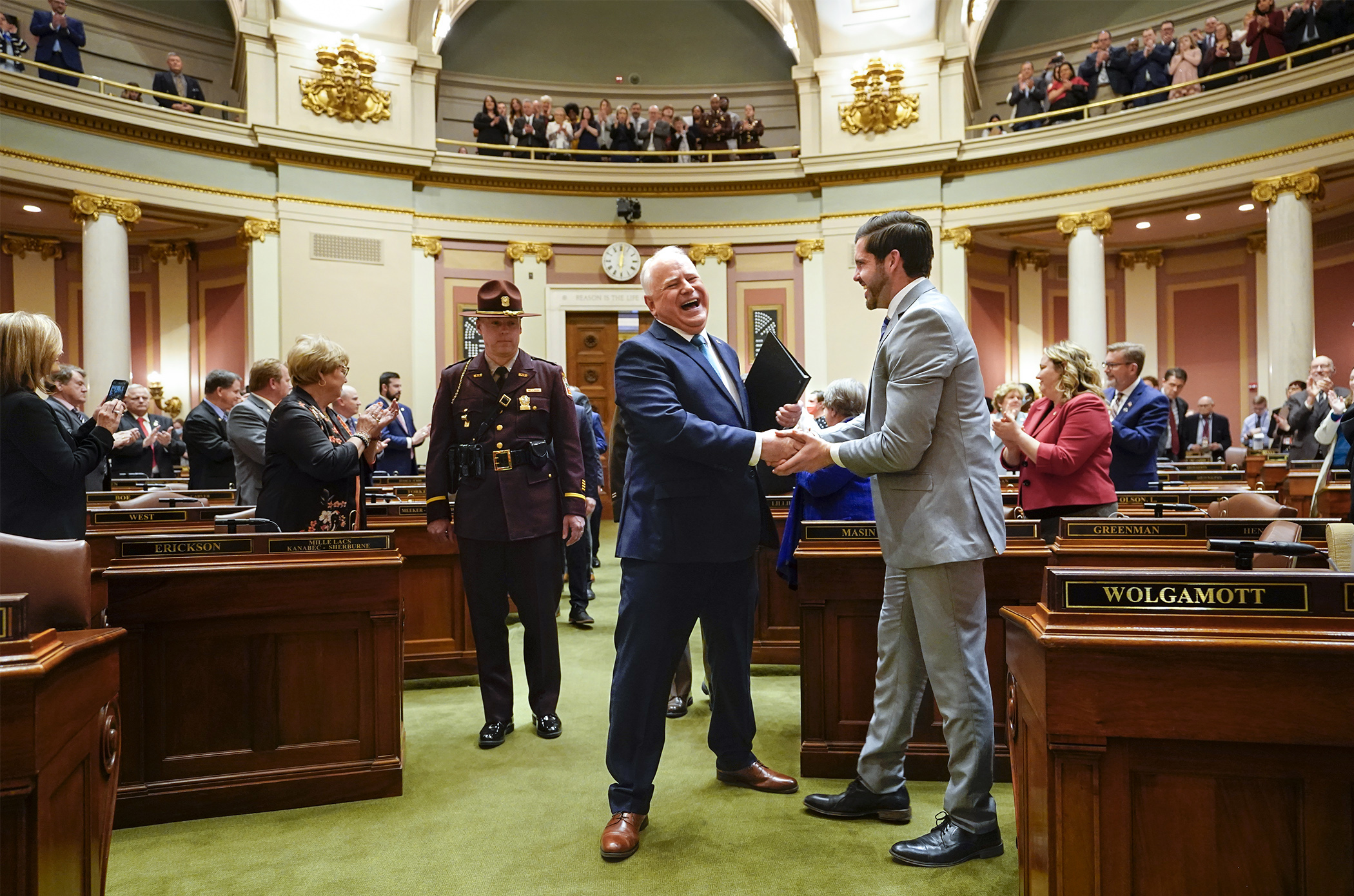 Rep. Dan Wolgamott, right, greets Gov. Tim Walz as he enters the House Chamber to give his State of the State address April 24. Photo by Paul Battaglia