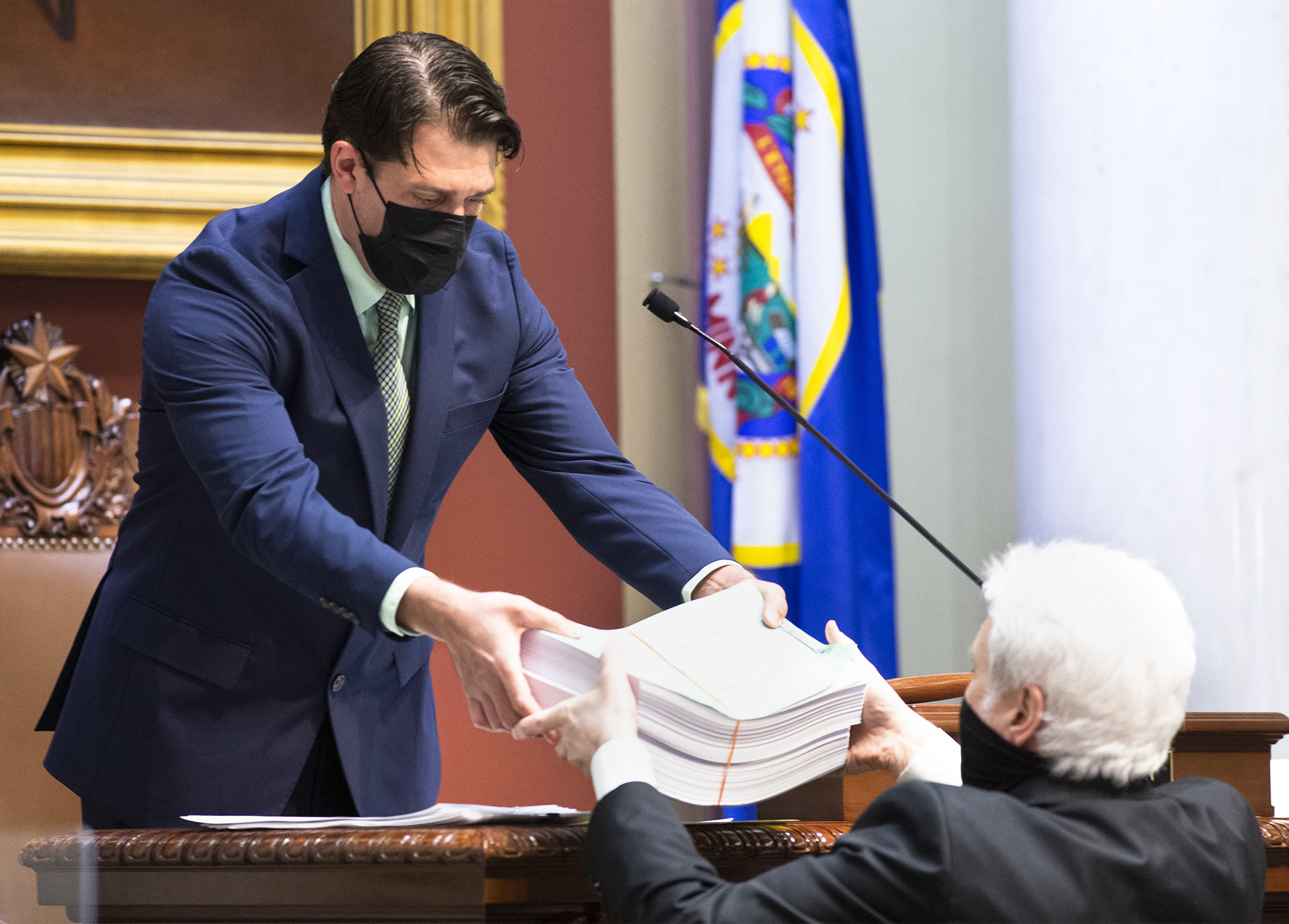 House Speaker Pro-Tempore Andrew Carlson hands the 970-page omnibus health and human services bill to Chief Clerk Pat Murphy at the beginning of floor debate April 26. Photo by Paul Battaglia