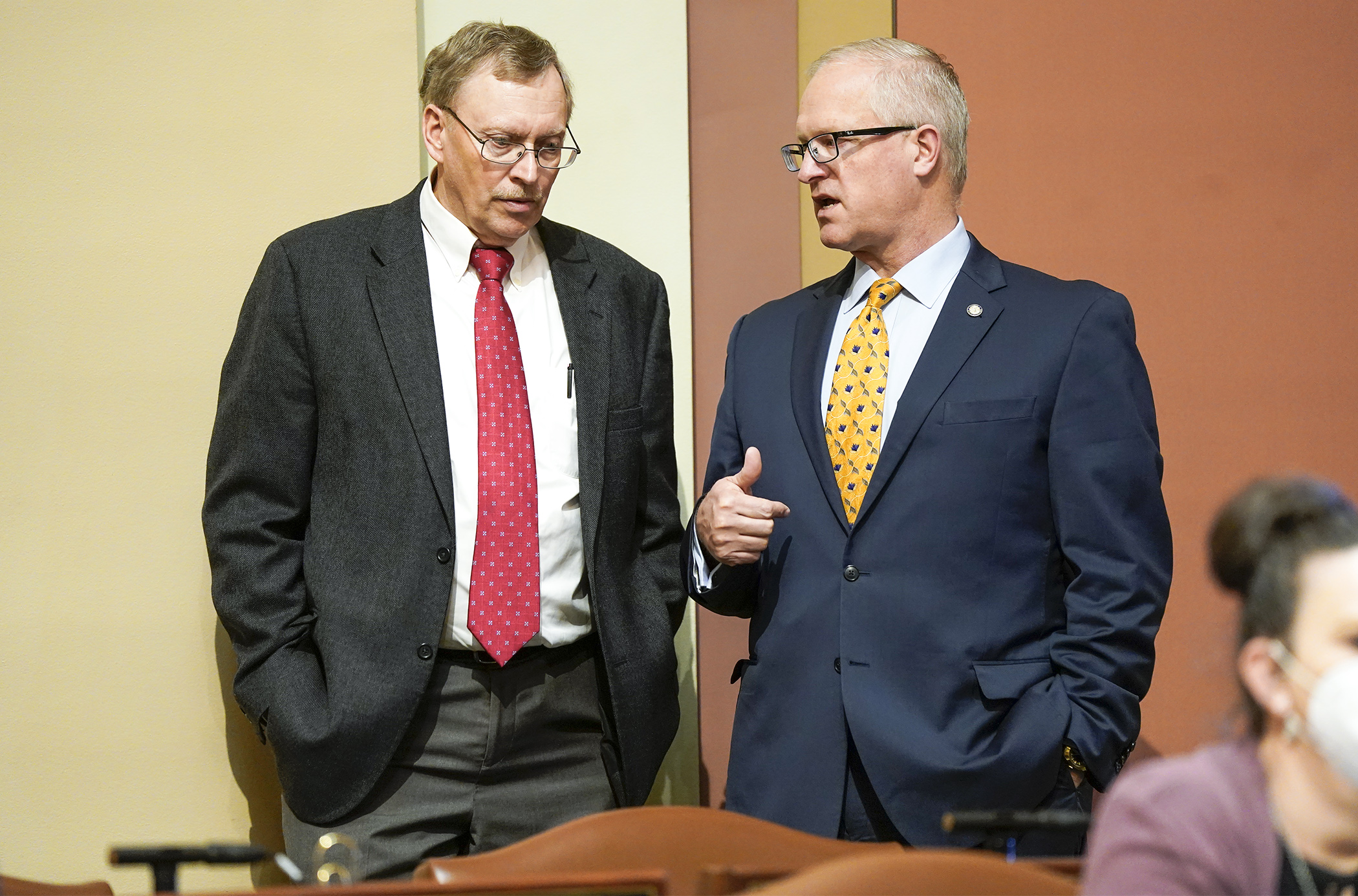 Rep. Michael Nelson, chair of the House State Government Finance and Elections Committee, confers with Rep. Jim Nash before the House took up HF4293 during the April 26 floor session. (Photo by Paul Battaglia)