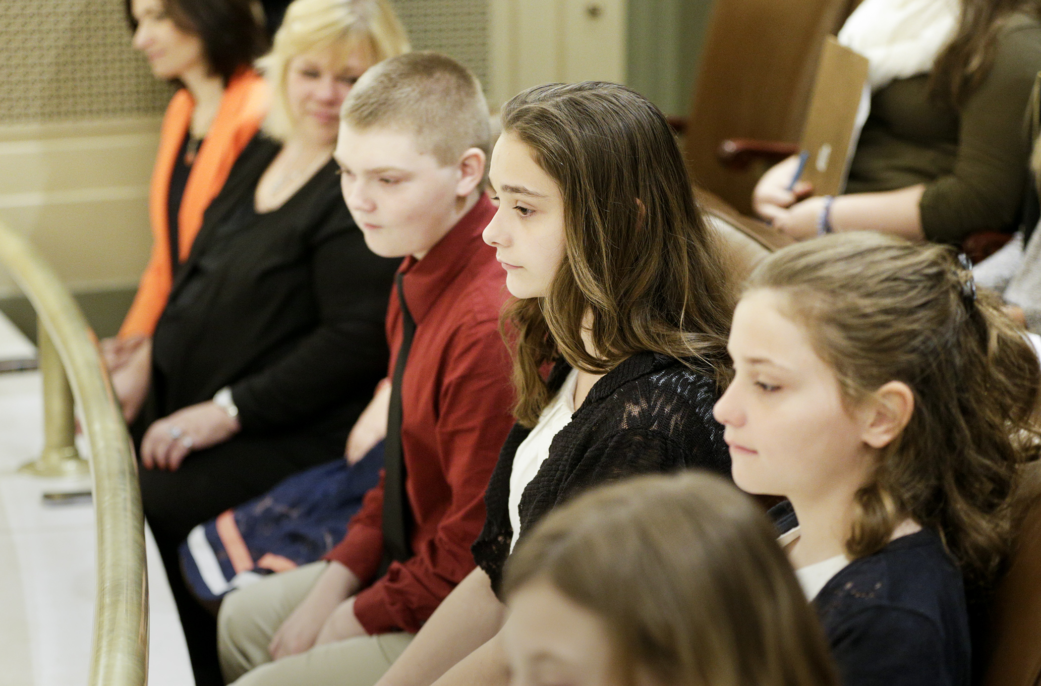 McKenna Ahrenholz, center, sits in the House Gallery April 27 as members debate a bill the 12-year-old inspired when she wrote to legislators about her experience with the state’s child protection system. The bill, HF1702 would, in part, require that children at least age 10 be notified of their rights to free counsel in certain cases. Photo by Paul Battaglia