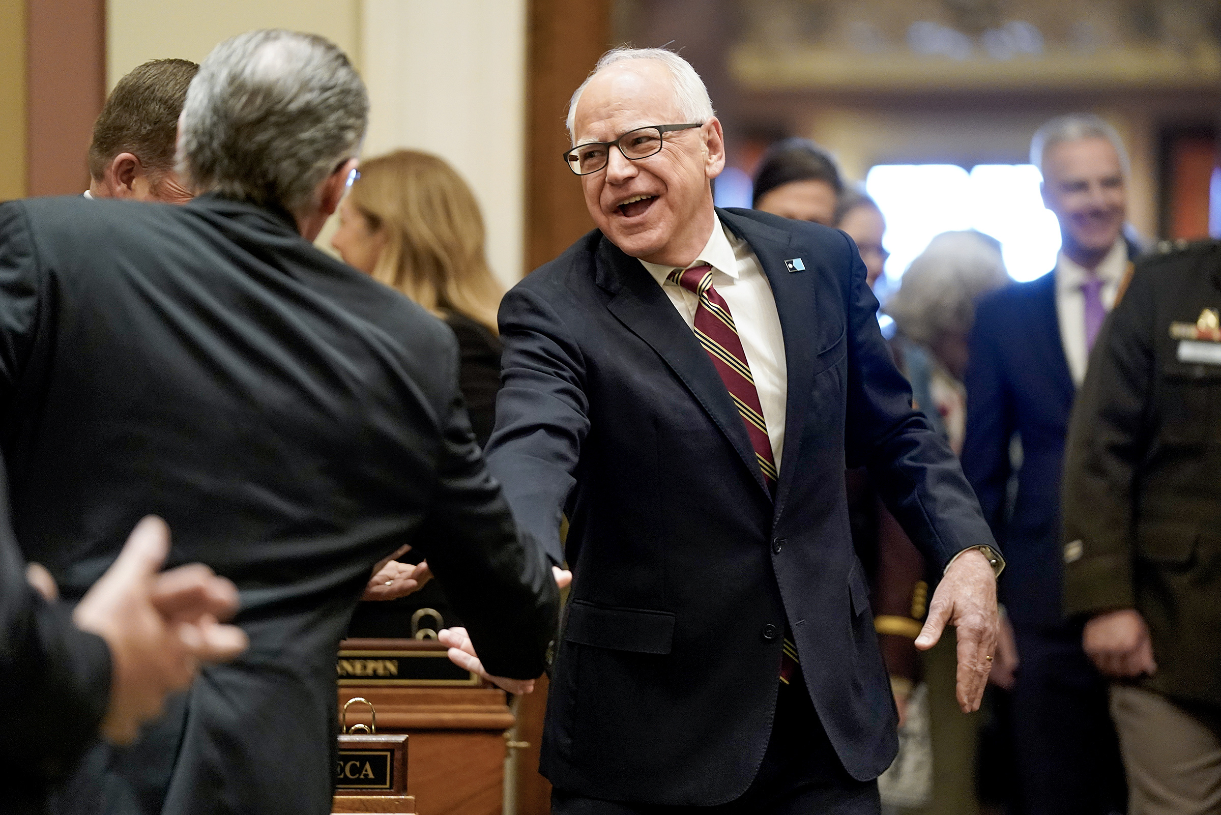 Gov. Tim Walz greets lawmakers and guests as he makes his way to the rostrum to deliver his final State of the State address to a joint session of the Legislature April 28. (Photo by Michele Jokinen)