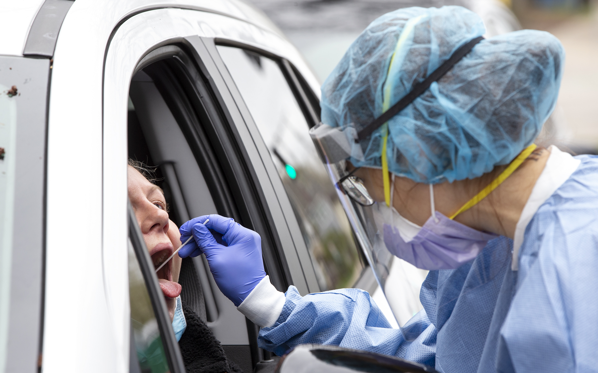 A health care worker takes a swab from a client at the drive-up COVID-19 testing site at the People’s Center Clinics and Services in Minneapolis April 29. Photo by Paul Battaglia