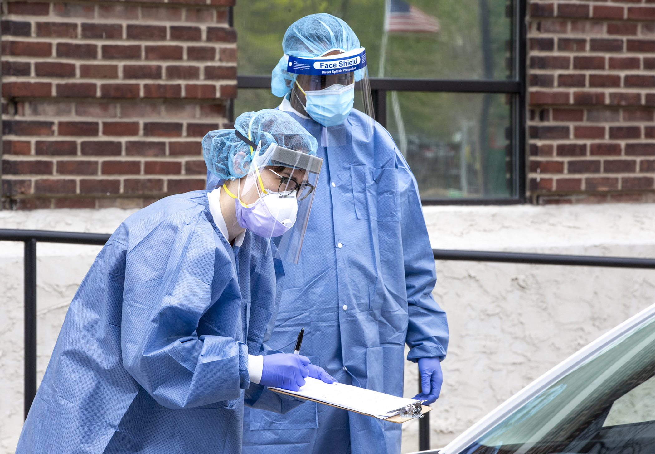 Health care workers gather information from a patient at a Minneapolis drive-up COVID-19 testing site April 29. Photo by Paul Battaglia