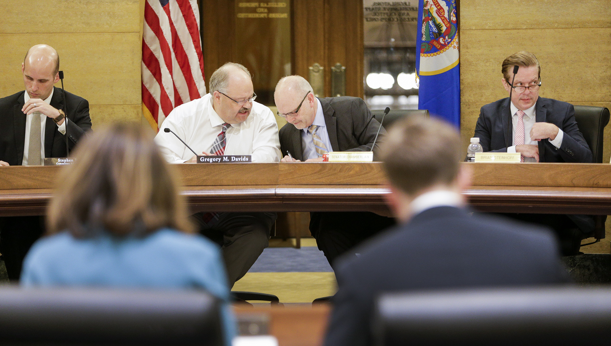 House Taxes Committee Chair Greg Davids, left, and Senate Taxes Committee Chair Roger Chamberlain confer as staff goes through the provisions of the proposed conference committee report on the omnibus tax bill. Photo by Paul Battaglia