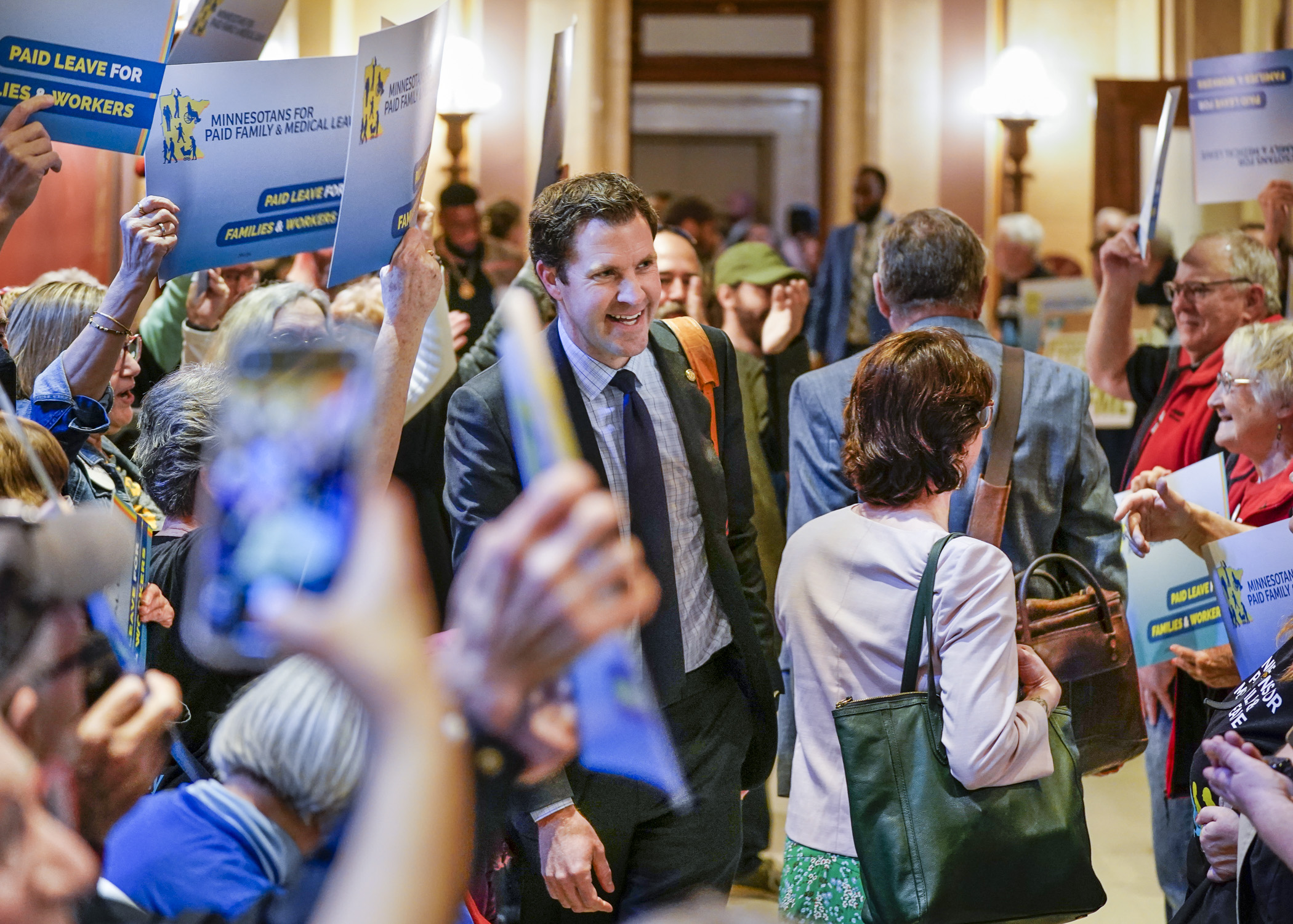 House Majority Leader Jamie Long greets supporters of HF2, the paid family and medical leave bill, on his way into the House Chamber May 2. (Photo by Catherine Davis)