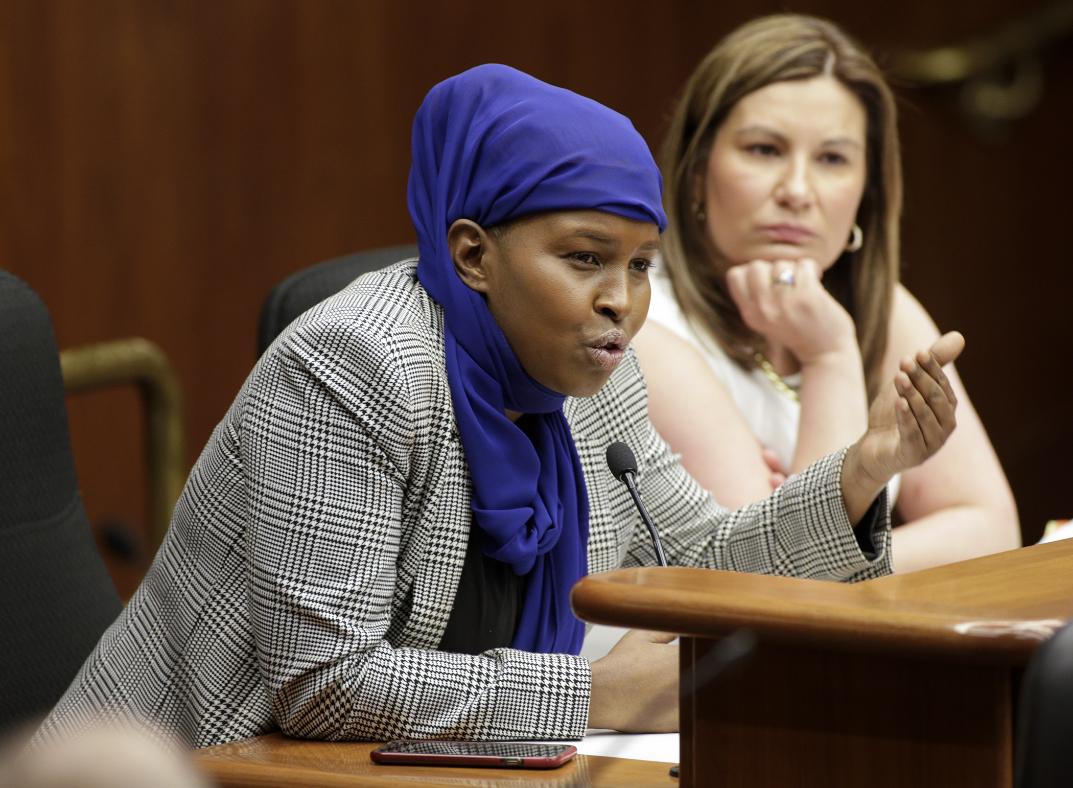 Farhio Klalif responds to a question after providing emotional testimony about her experience as a young girl in Somalia. Klalif shared her story at a May 3 House Civil Law and Data Practices Policy Committee hearing on HF2621, sponsored by Rep. Mary Franson, right. Photo by Paul Battaglia