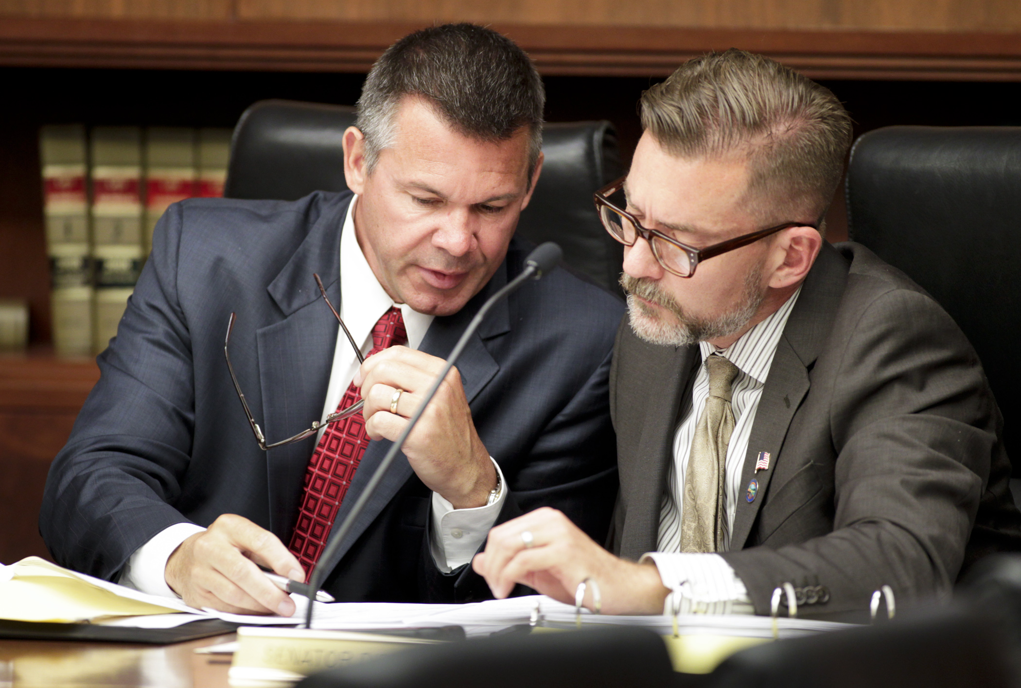 Rep. Tim Kelly, left, and Sen. D. Scott Dibble confer as members listen to a side-by-side comparison of the two bills during the first meeting of the conference committee on the omnibus transportation policy and finance bill May 6. Photo by Paul Battaglia