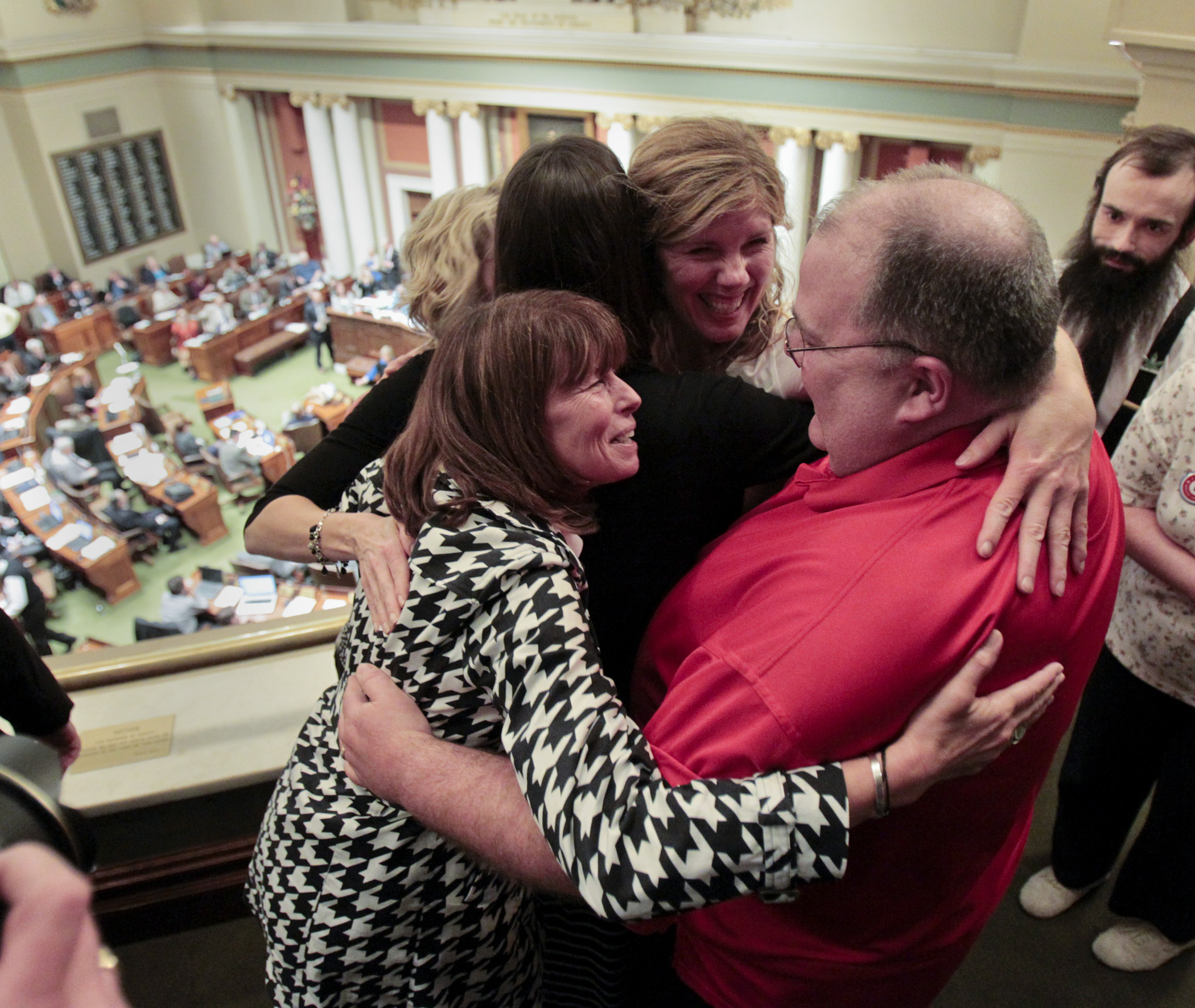 Medical marijuana supporters hug in the House gallery Friday after SF2470 passed the House 86-39. Photo by Paul Battaglia