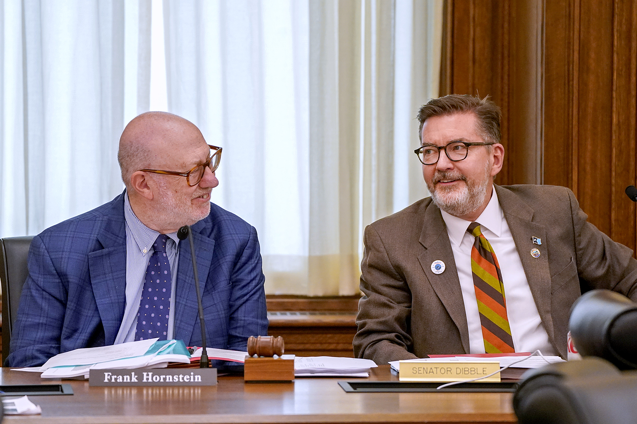 Rep. Frank Hornstein and Sen. D. Scott Dibble chat before convening the May 10 meeting of the conference committee for HF5242 – the transportation, labor and housing supplemental budget bill. (Photo by Michele Jokinen)