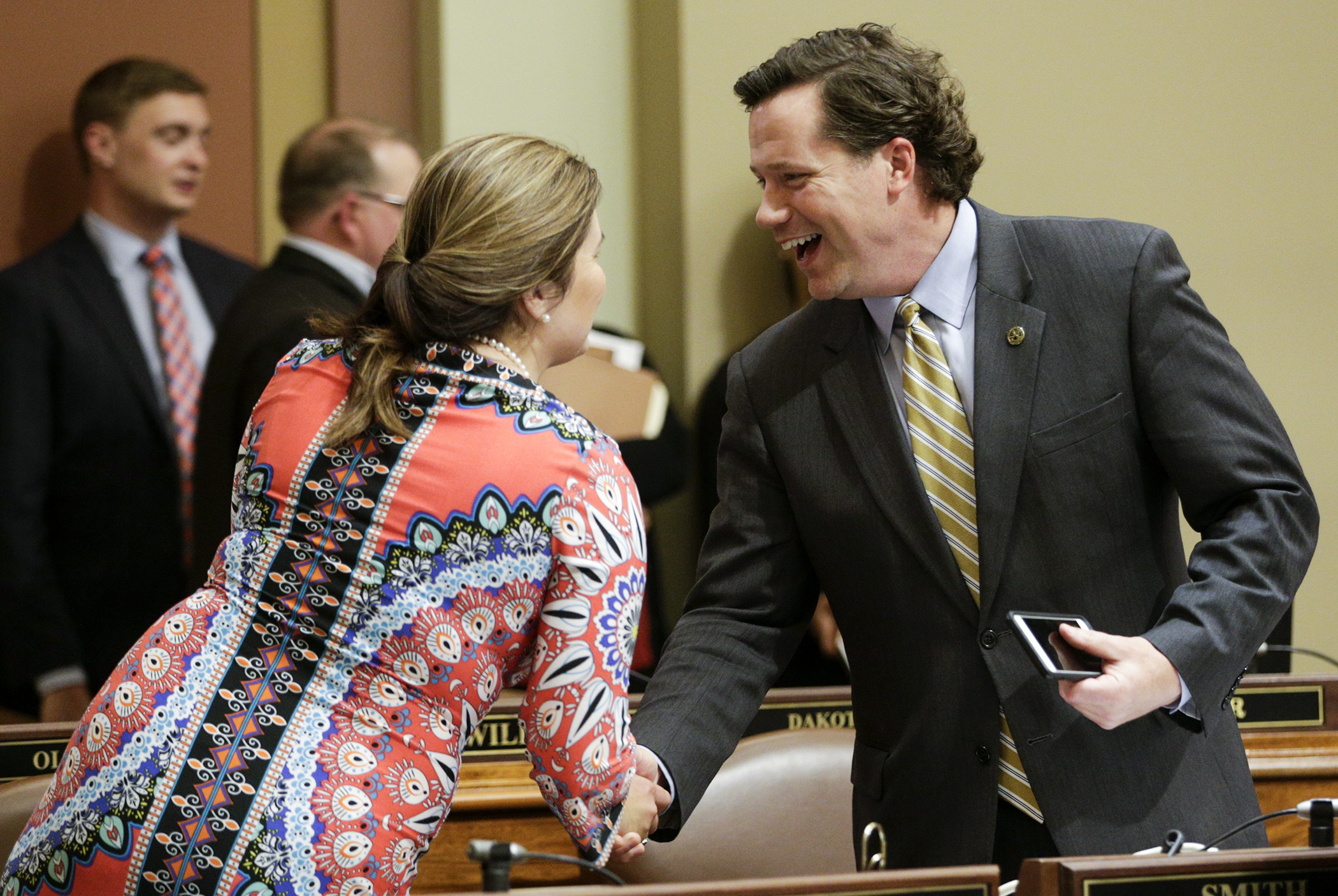 Rep. Dennis Smith is congratulated by Rep. Mary Franson after the conference committee report on Real ID was passed May 17 by the House. Photo by Paul Battaglia