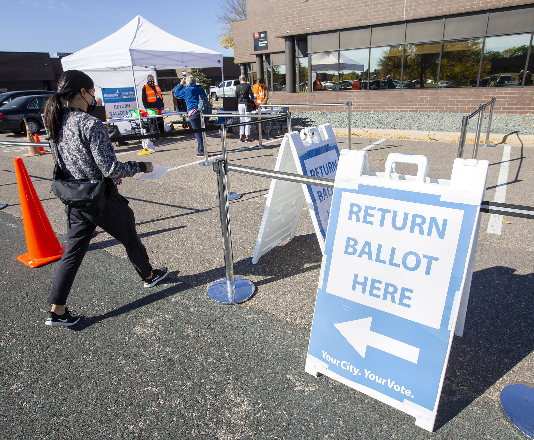 A voter returns her ballot to the Minneapolis Early Voting Center in October 2020. Photo by Paul Battaglia