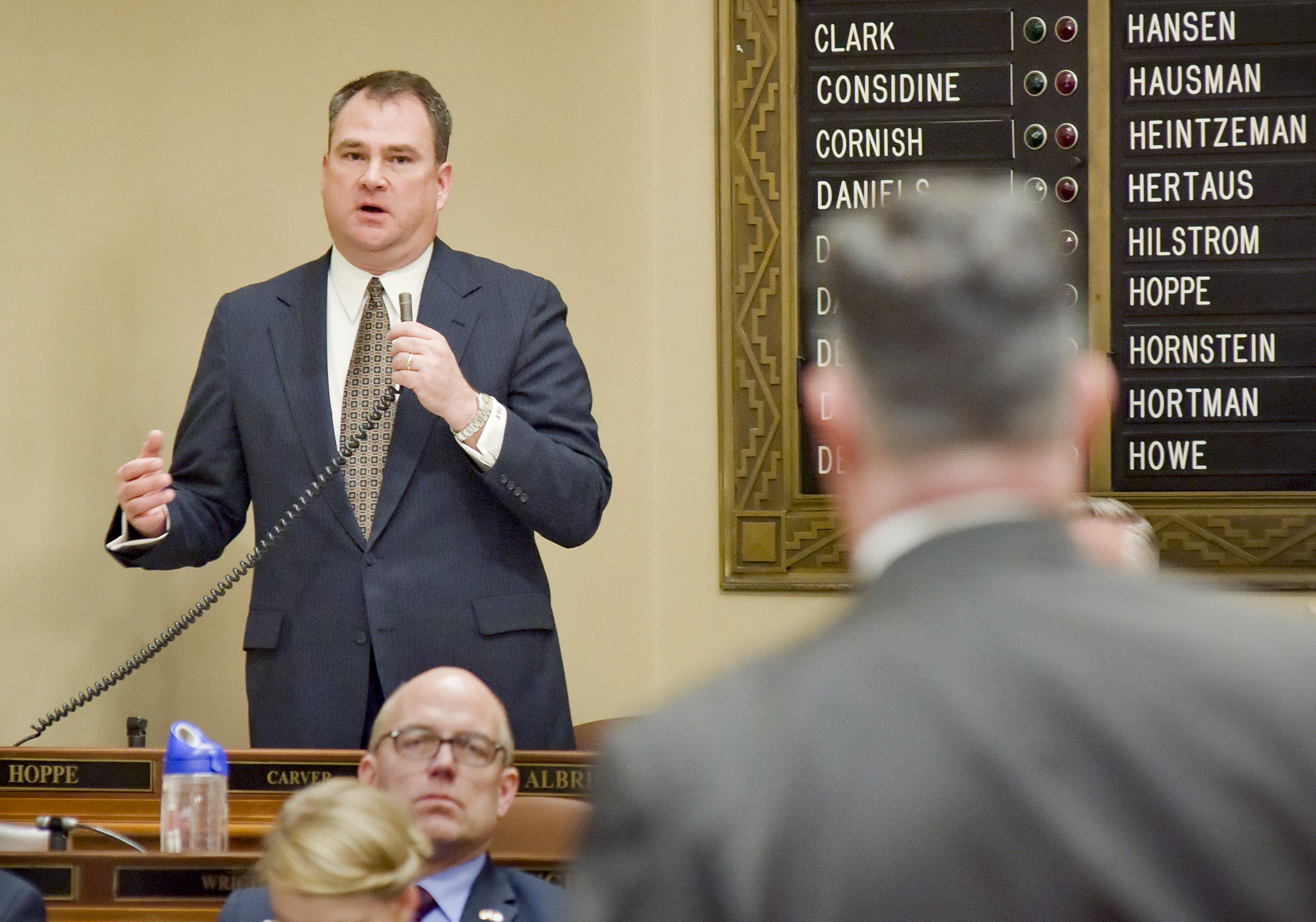 Rep. Joe Hoppe responds to a question by Rep. John Lesch, foreground, during Thursday’s floor debate on whether to suspend House Rules to take up House File 1. Photo by Andrew VonBank.