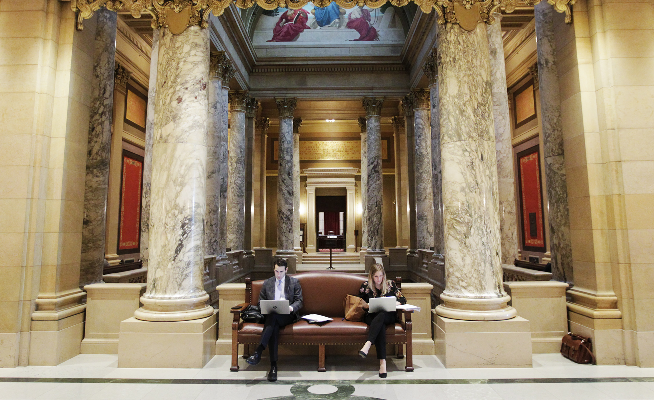 Lobbyists Meredith Campbell and Brian Carr find a grand spot to work just off the Capitol Rotunda Jan. 24. Photo by Paul Battaglia